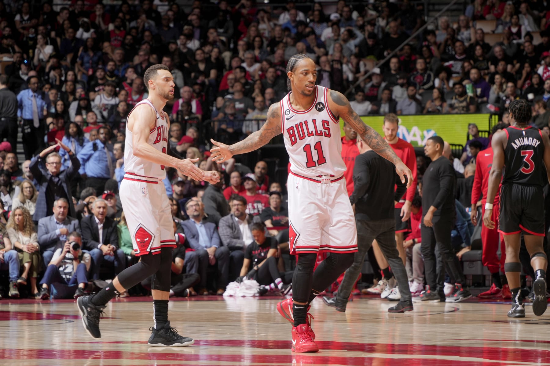 TORONTO, CANADA - APRIL 12:  DeMar DeRozan #11 high fives Zach LaVine #8 of the Chicago Bulls during the game against the Toronto Raptors during the 2023 Play-In Tournament on April 12, 2023 at the Scotiabank Arena in Toronto, Ontario, Canada.  NOTE TO USER: User expressly acknowledges and agrees that, by downloading and or using this Photograph, user is consenting to the terms and conditions of the Getty Images License Agreement.  Mandatory Copyright Notice: Copyright 2022 NBAE (Photo by Mark Blinch/NBAE via Getty Images)