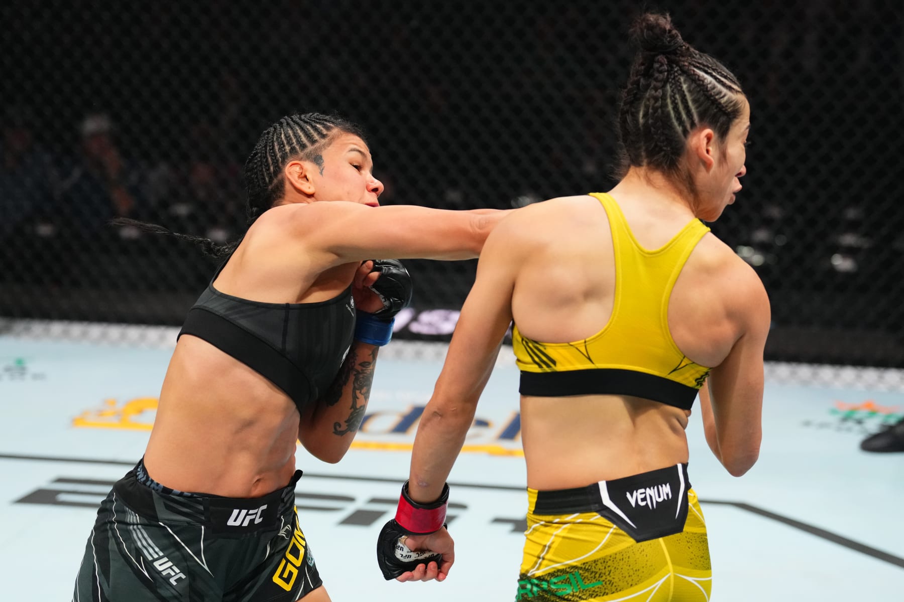KANSAS CITY, MISSOURI - APRIL 15: (L-R) Denise Gomes of Brazil punches Bruna Brasil of Brazil in a strawweight fight during the UFC Fight Night event at T-Mobile Center on April 15, 2023 in Kansas City, Missouri. (Photo by Josh Hedges/Zuffa LLC via Getty Images)