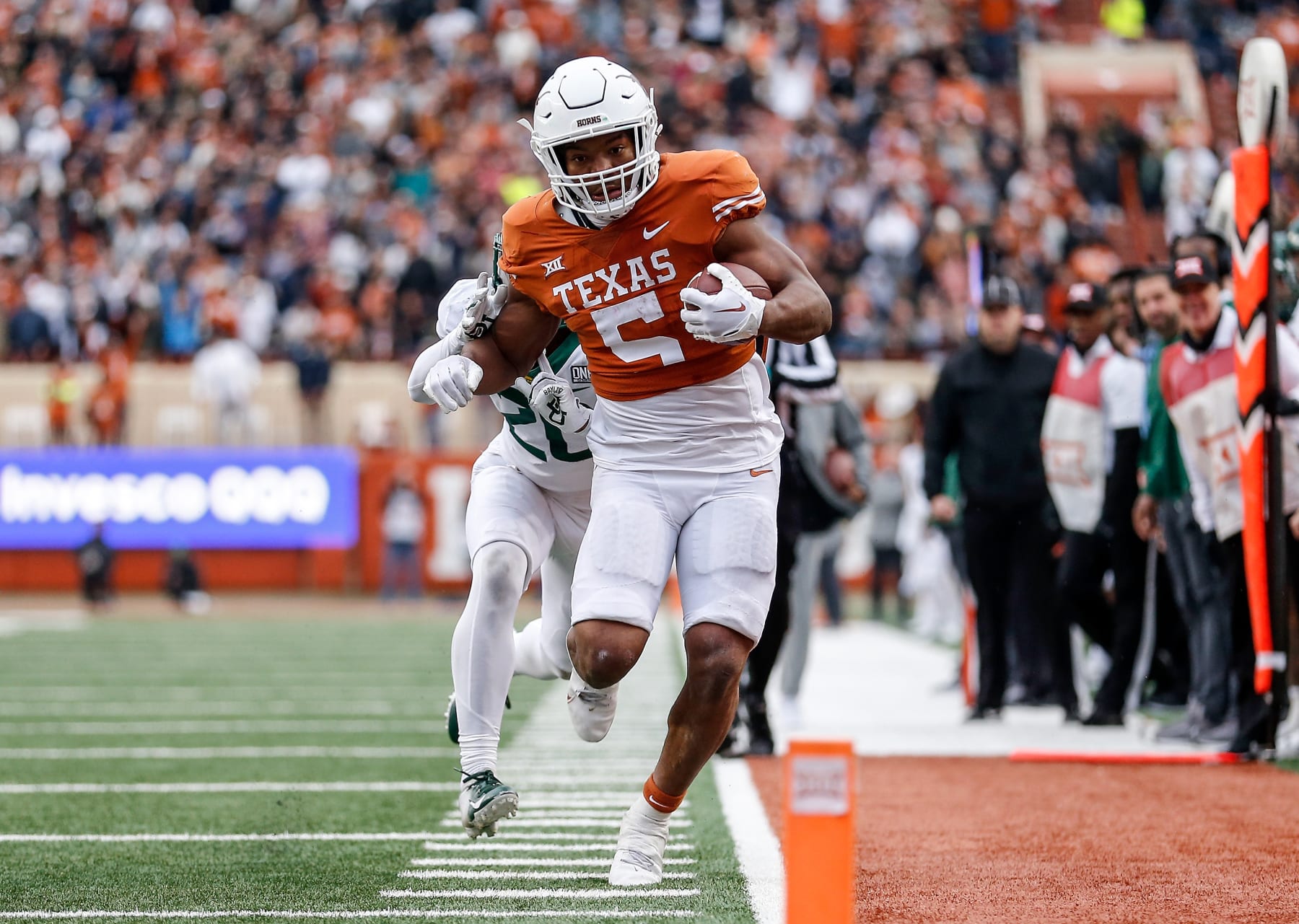AUSTIN, TEXAS - NOVEMBER 25: Bijan Robinson #5 of the Texas Longhorns runs the ball in the fourth quarter defended by Devin Lemear #20 of the Baylor Bears at Darrell K Royal-Texas Memorial Stadium on November 25, 2022 in Austin, Texas. (Photo by Tim Warner/Getty Images)