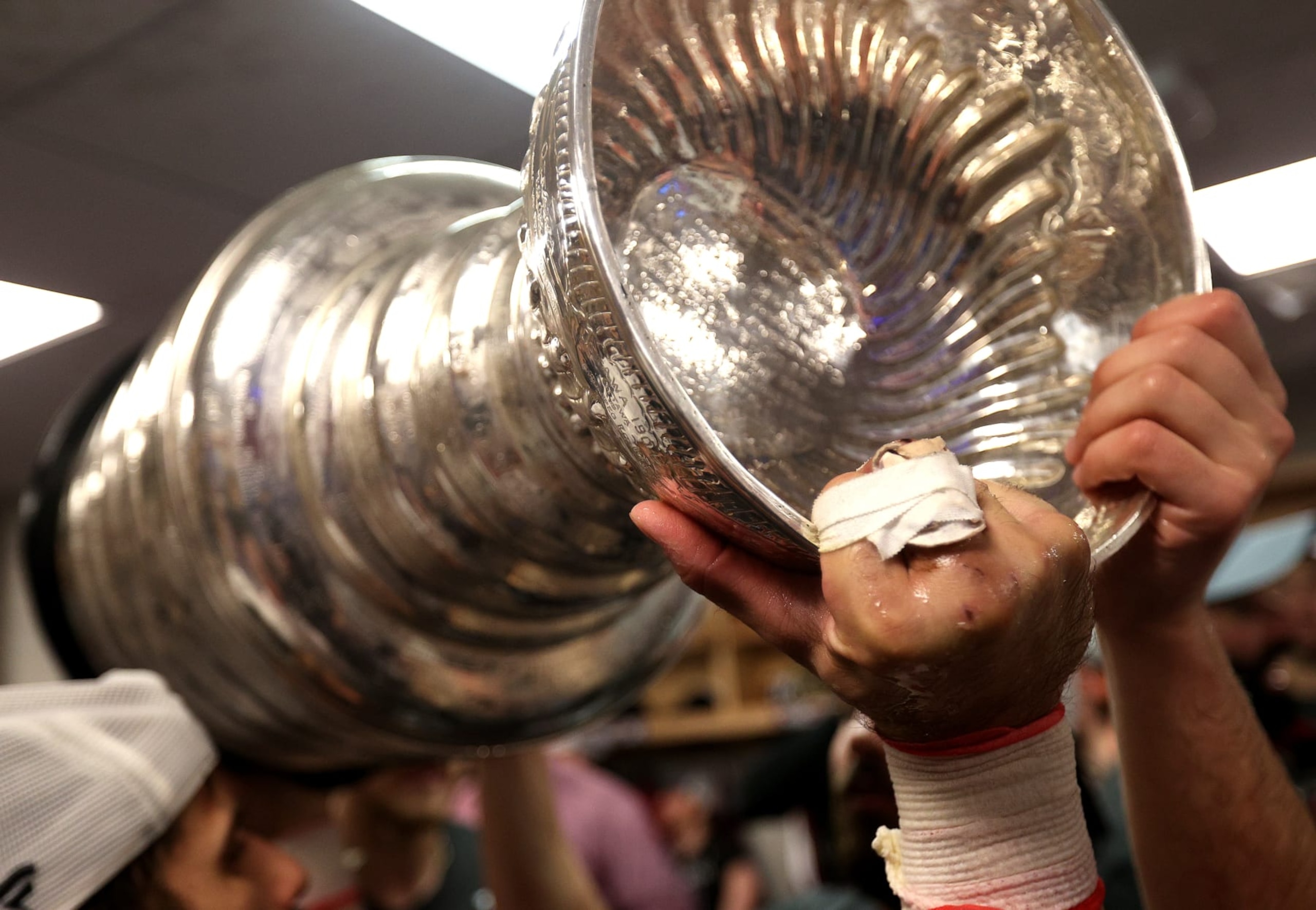 TAMPA, FLORIDA - JUNE 26: Andrew Cogliano #11 of the Colorado Avalanche hoists the Stanley Cup in the locker room with his injured right hand after Game Six of the 2022 Stanley Cup Final at Amalie Arena on June 26, 2022 in Tampa, Florida. The Colorado Avalanche defeated the Tampa Bay Lightning 2-1 in Game Six to take the best of seven Stanley Cup Final series 4 games to 2.  (Photo by Dave Sandford/NHLI via Getty Images)