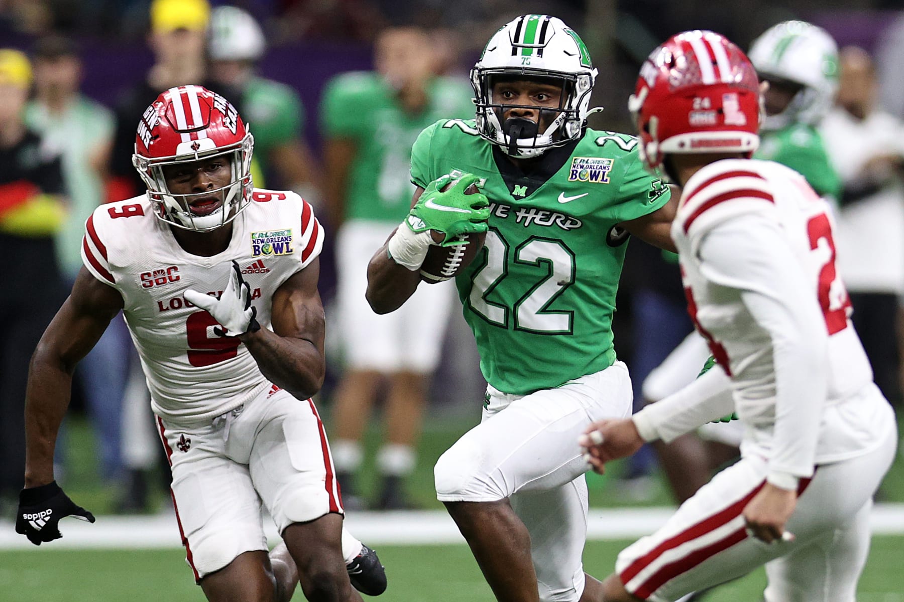 NEW ORLEANS, LOUISIANA - DECEMBER 18: Rasheen Ali #22 of the Marshall Thundering Herd avoids a tackle by Bralen Trahan #24 of the Louisiana-Lafayette Ragin Cajuns during the R+L Carriers New Orleans Bowl at Caesars Superdome on December 18, 2021 in New Orleans, Louisiana. (Photo by Chris Graythen/Getty Images)