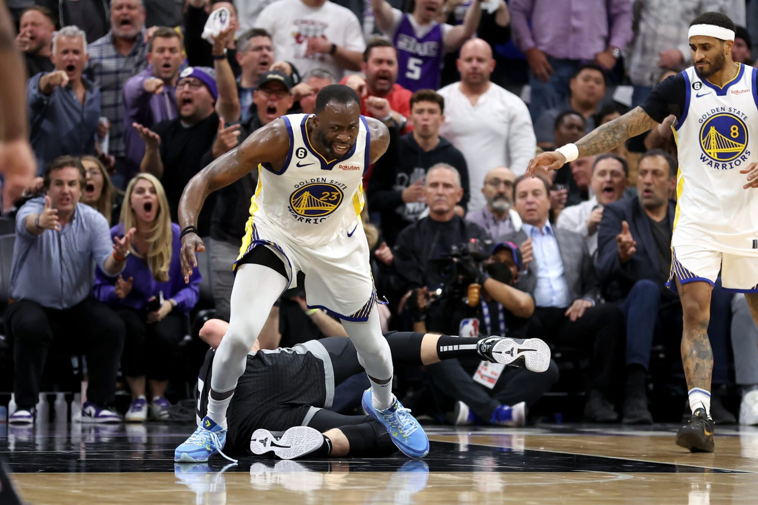 SACRAMENTO, CALIFORNIA - APRIL 17: Draymond Green #23 of the Golden State Warriors steps over Domantas Sabonis #10 of the Sacramento Kings in the second half during Game Two of the Western Conference First Round Playoffs at Golden 1 Center on April 17, 2023 in Sacramento, California. Green was issued a flagrant foul 2 on the play, and ejected from the game. NOTE TO USER: User expressly acknowledges and agrees that, by downloading and or using this photograph, User is consenting to the terms and conditions of the Getty Images License Agreement. (Photo by Ezra Shaw/Getty Images)