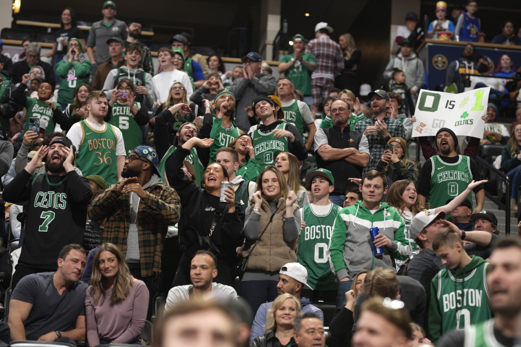 Boston Celtics fans cheer in the second half of an NBA basketball game against the Denver Nuggets, Sunday, Jan. 1, 2023, in Denver. (AP Photo/David Zalubowski)