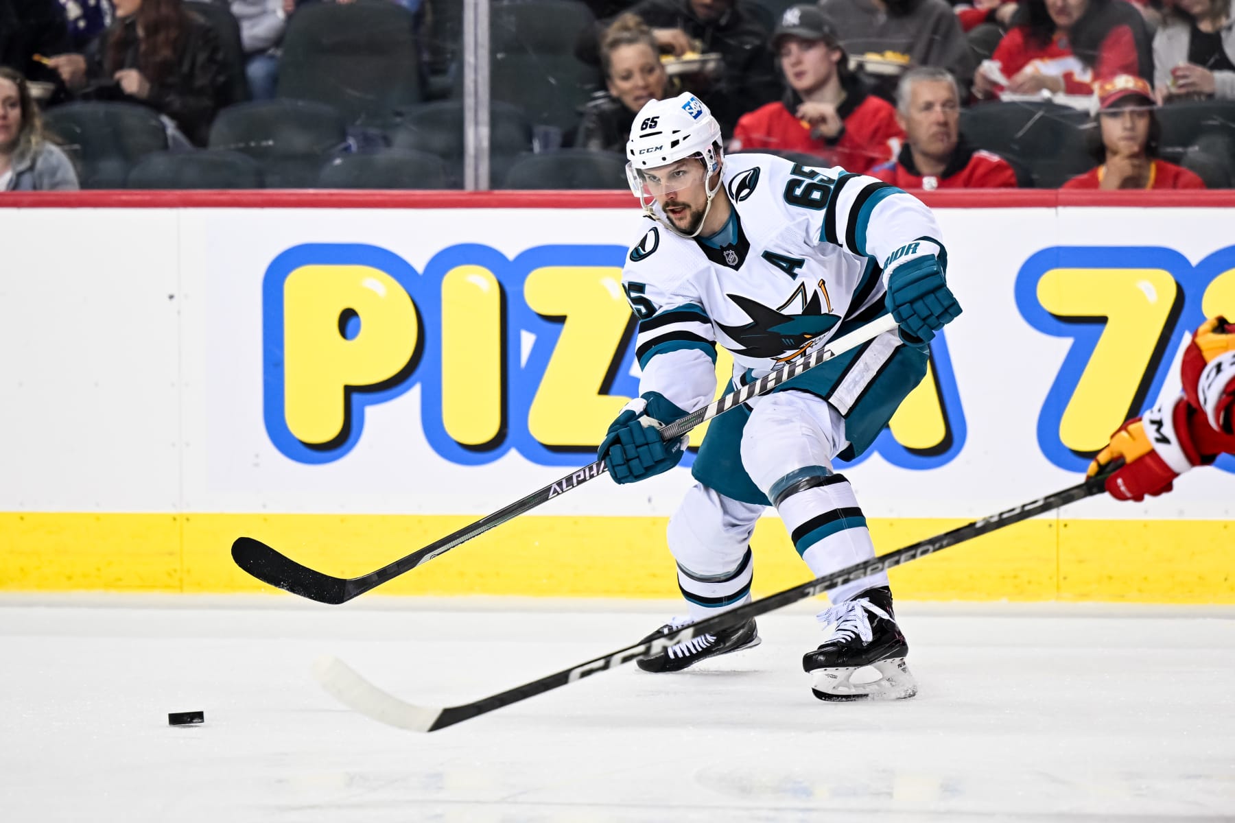 CALGARY, AB - APRIL 12: San Jose Sharks Defenceman Erik Karlsson (65) passes the puck during the second period of an NHL game between the Calgary Flames and the San Jose Sharks on April 12, 2023, at the Scotiabank Saddledome in Calgary, AB. (Photo by Brett Holmes/Icon Sportswire via Getty Images)