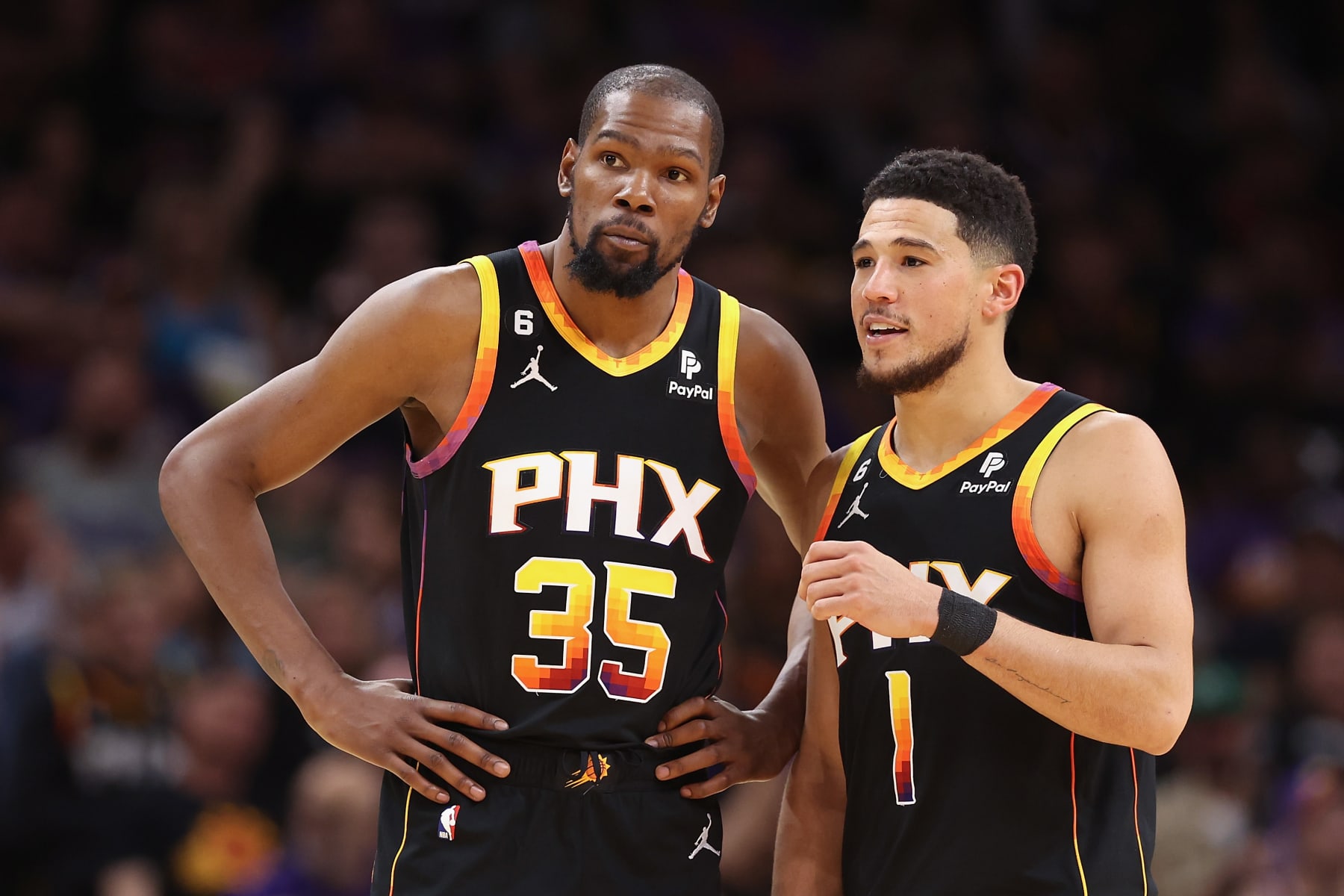 PHOENIX, ARIZONA - APRIL 18: Kevin Durant #35 and Devin Booker #1 of the Phoenix Suns talk during the second half of Game Two of the Western Conference First Round Playoffs against the LA Clippers at Footprint Center on April 18, 2023 in Phoenix, Arizona. The Suns defeated the Clippers 123-109. NOTE TO USER: User expressly acknowledges and agrees that, by downloading and or using this photograph, User is consenting to the terms and conditions of the Getty Images License Agreement.  (Photo by Christian Petersen/Getty Images)