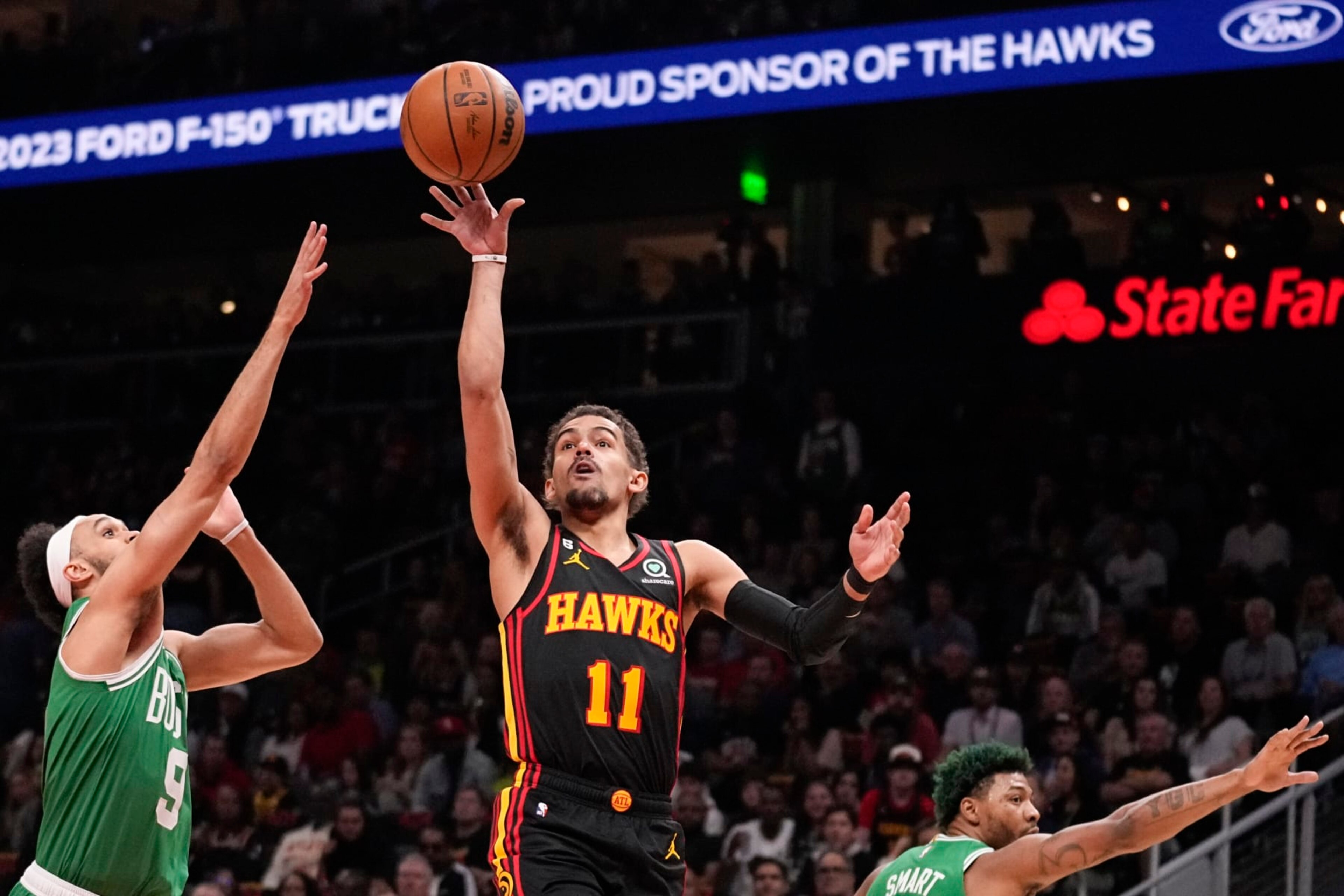 Atlanta Hawks guard Trae Young (11) shoots against Boston Celtics guard Derrick White (9) during the first half of Game 3 of a first-round NBA basketball playoff series, Friday, April 21, 2023, in Atlanta. (AP Photo/Brynn Anderson)