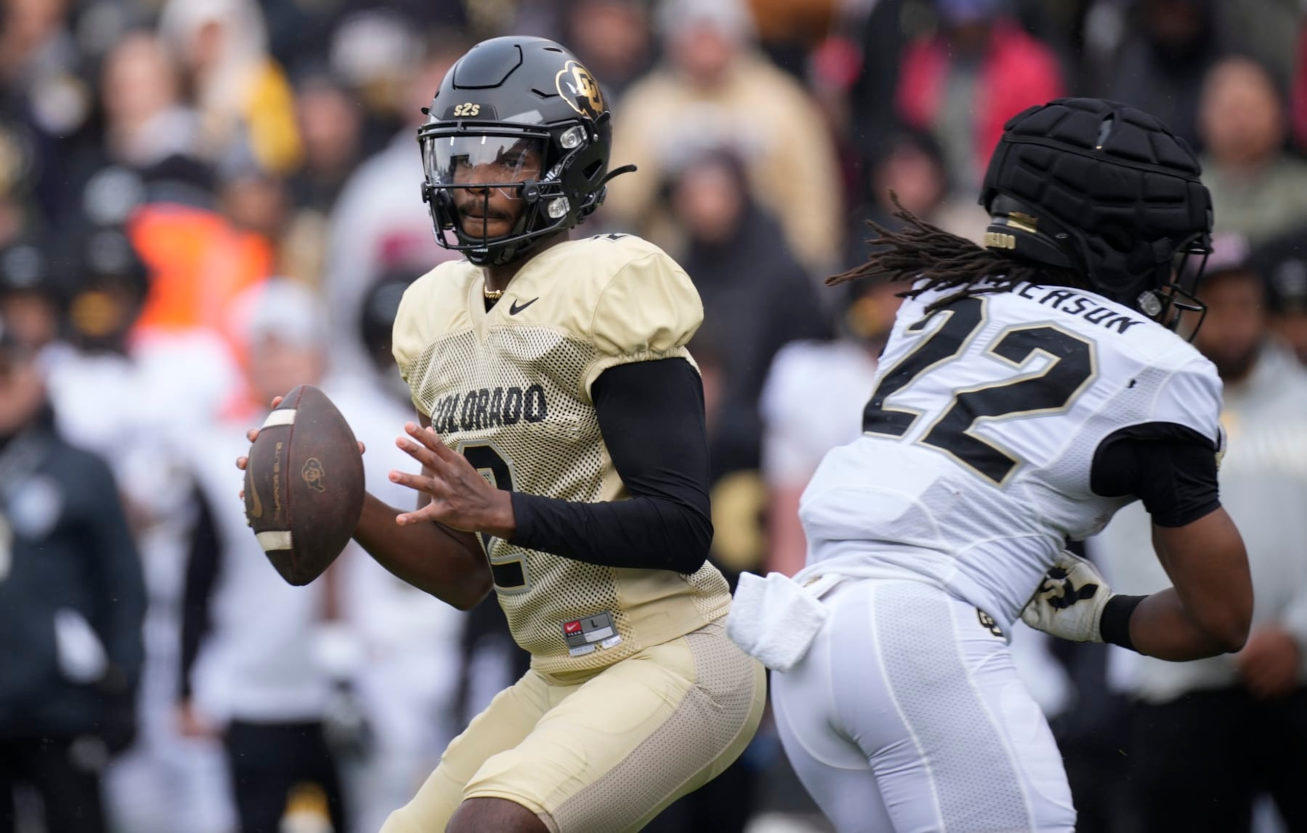 Colorado quarterback Shedeur Sanders, left, rolls out to pass the ball as running back Anthony Hankerson blocks in the first half of the team's spring practice NCAA college football game Saturday, April 22, 2023, in Boulder, Colo. (AP Photo/David Zalubowski)