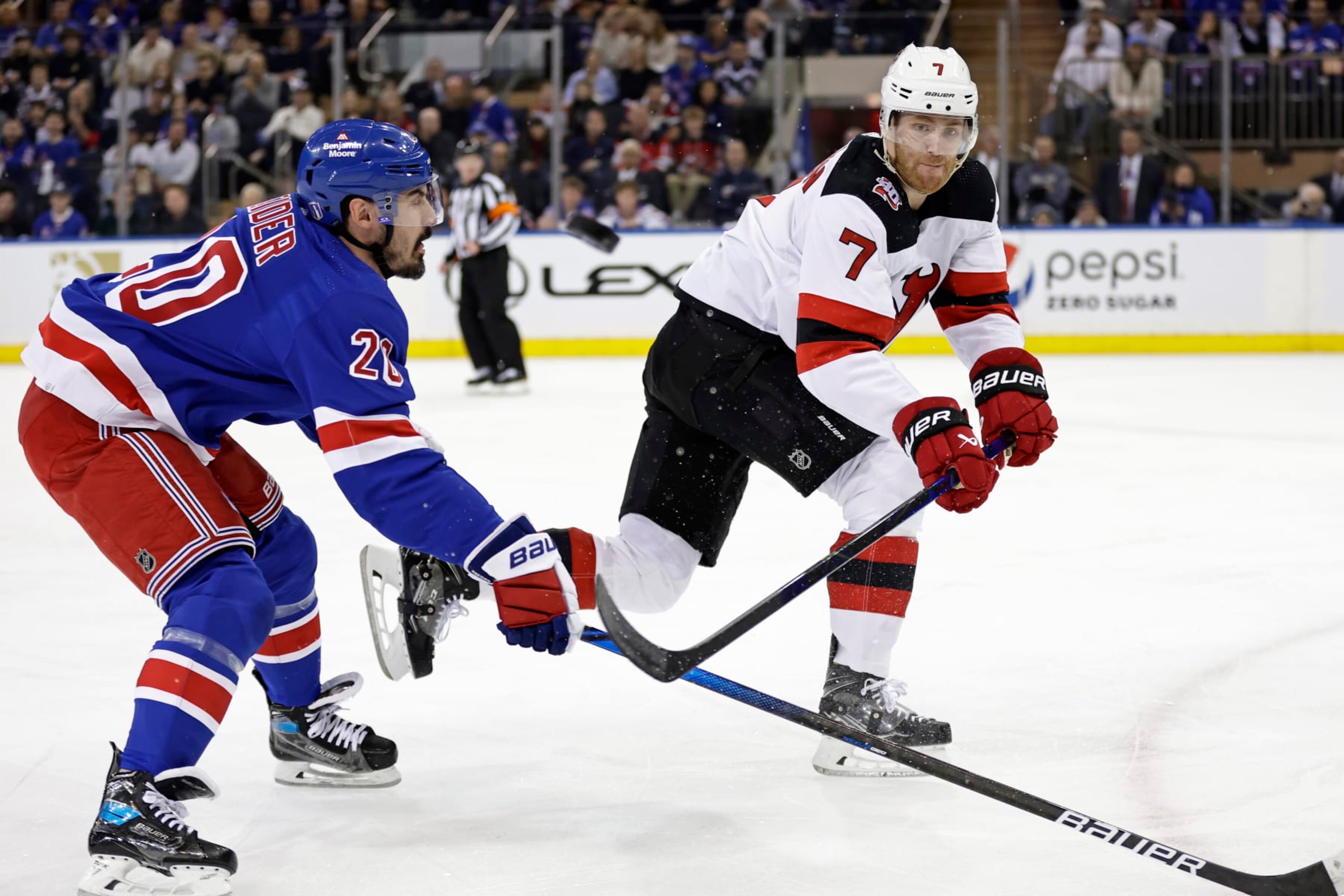 New Jersey Devils defenseman Dougie Hamilton (7) clears the puck past New York Rangers left wing Chris Kreider during the first period of Game 3 of the team's NHL hockey Stanley Cup first-round playoff series Saturday, April 22, 2023, in New York. (AP Photo/Adam Hunger) New Jersey Devils defenseman Dougie Hamilton (7) clears the puck past New York Rangers left wing Chris Kreider during the first period of Game 3 of the team's NHL hockey Stanley Cup first-round playoff series Saturday, April 22, 2023, in New York. (AP Photo/Adam Hunger)