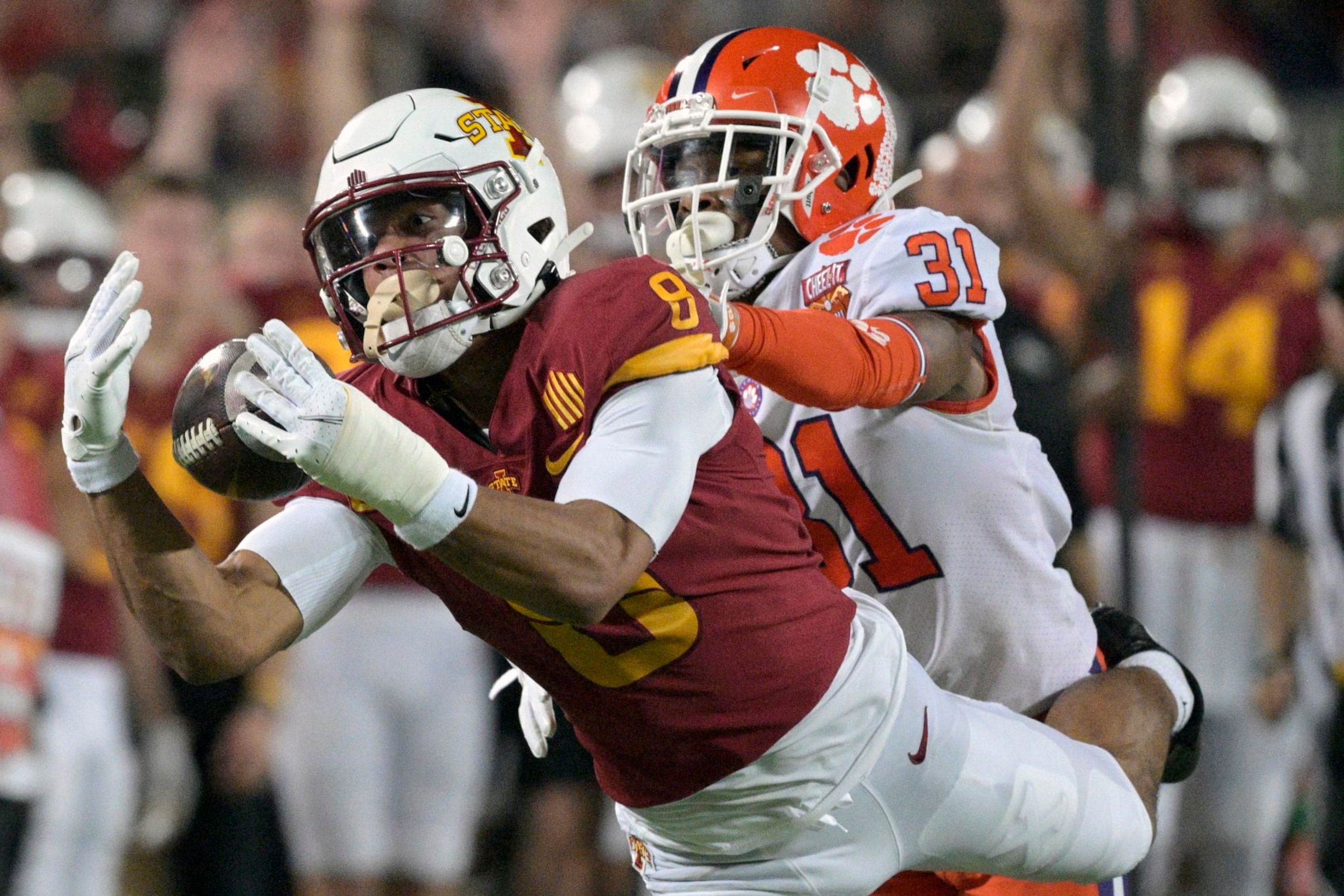 Iowa State wide receiver Xavier Hutchinson (8) catches a 34-yard pass in front of Clemson cornerback Mario Goodrich (31) during the first half of the Cheez-It Bowl NCAA college football game, Wednesday, Dec. 29, 2021, in Orlando, Fla. (AP Photo/Phelan M. Ebenhack)