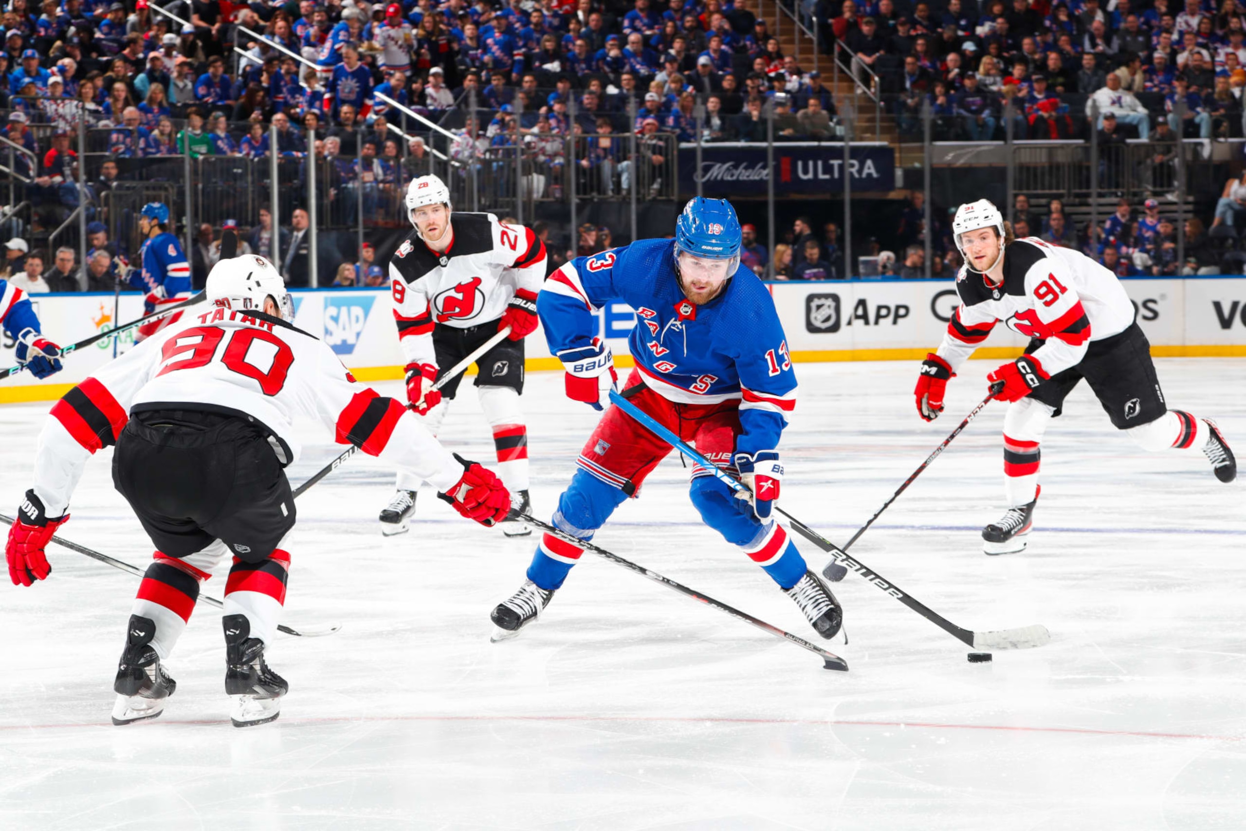 NEW YORK, NEW YORK - APRIL 22:  Alexis Lafreniere #13 of the New York Rangers skates with the puck against Tomas Tatar #90 of the New Jersey Devils in Game Three of the First Round of the 2023 Stanley Cup Playoffs at Madison Square Garden on April 22, 2023 in New York City. (Photo by Jared Silber/NHLI via Getty Images)