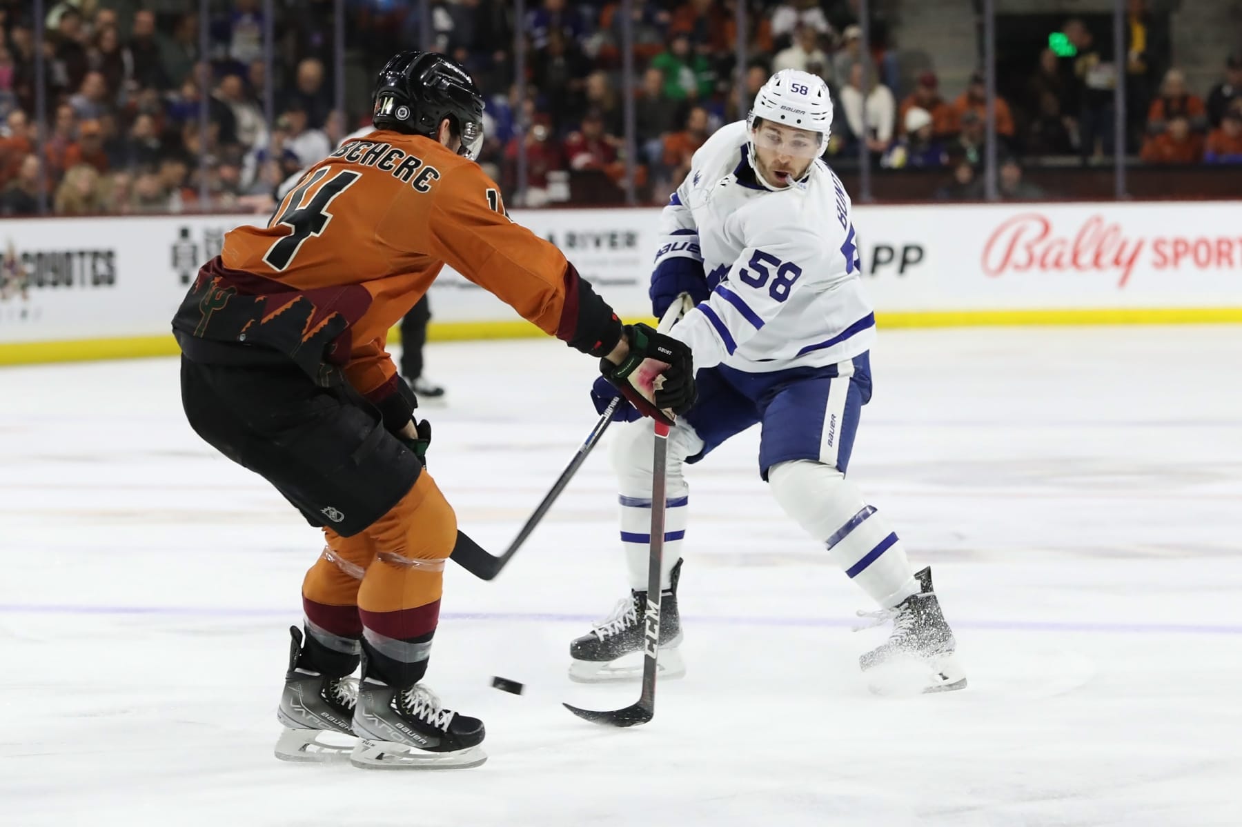 TEMPE, ARIZONA - DECEMBER 29: Michael Bunting #58 of the Toronto Maple Leafs takes a shot agianst Shayne Gostisbehere #14 of the Arizona Coyotes in the first period at Mullett Arena on December 29, 2022 in Tempe, Arizona. (Photo by Zac BonDurant/Getty Images)
