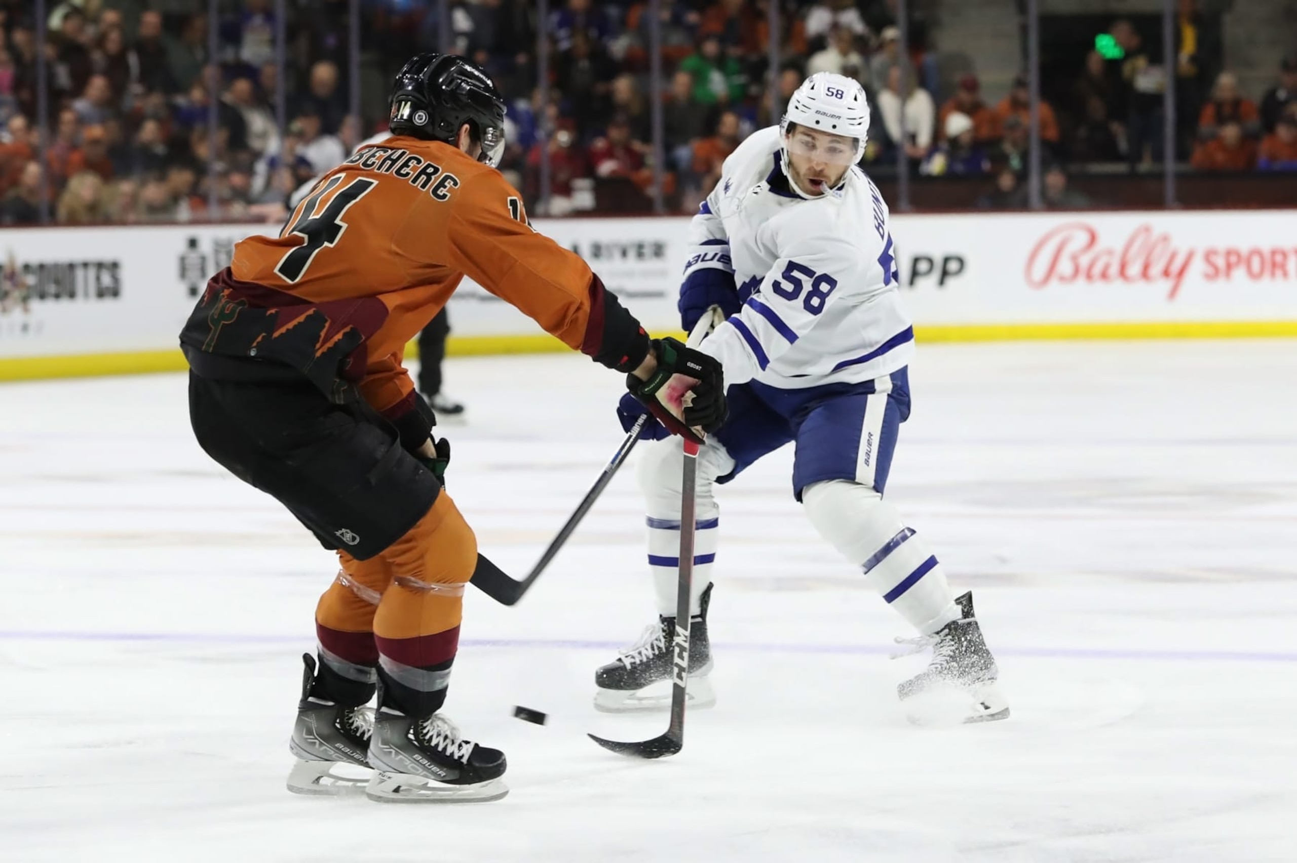 TEMPE, ARIZONA - DECEMBER 29: Michael Bunting #58 of the Toronto Maple Leafs takes a shot agianst Shayne Gostisbehere #14 of the Arizona Coyotes in the first period at Mullett Arena on December 29, 2022 in Tempe, Arizona. (Photo by Zac BonDurant/Getty Images)