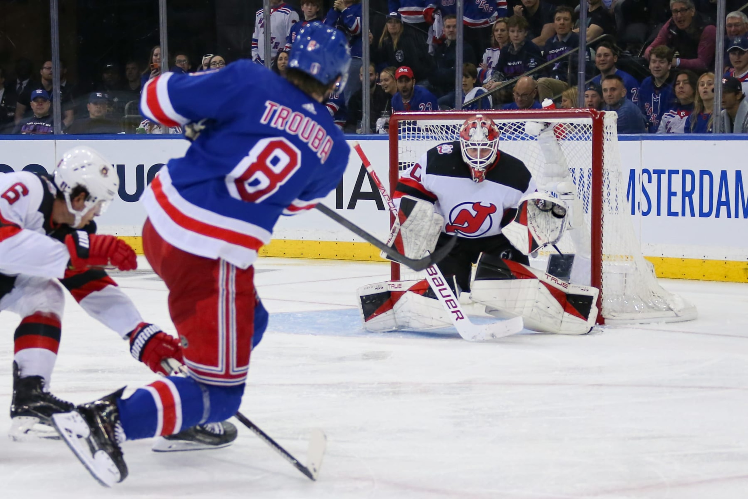 New York's Jacob Trouba sends a shot toward New Jersey's Akira Schmid