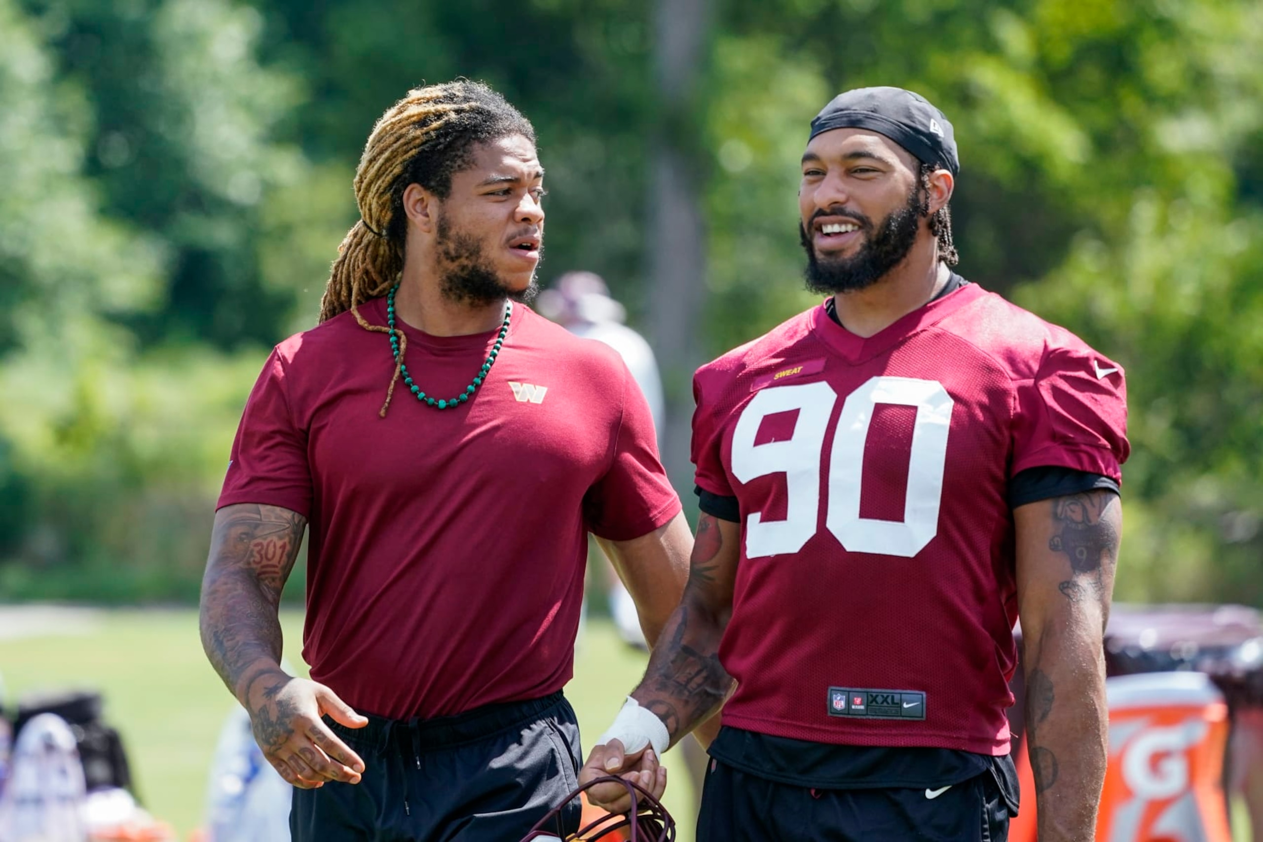 Washington Commanders defensive ends Chase Young, left, and Montez Sweat walk together after practice at the team's NFL football training facility, Thursday, Aug. 11, 2022, in Ashburn, Va. (AP Photo/Alex Brandon)