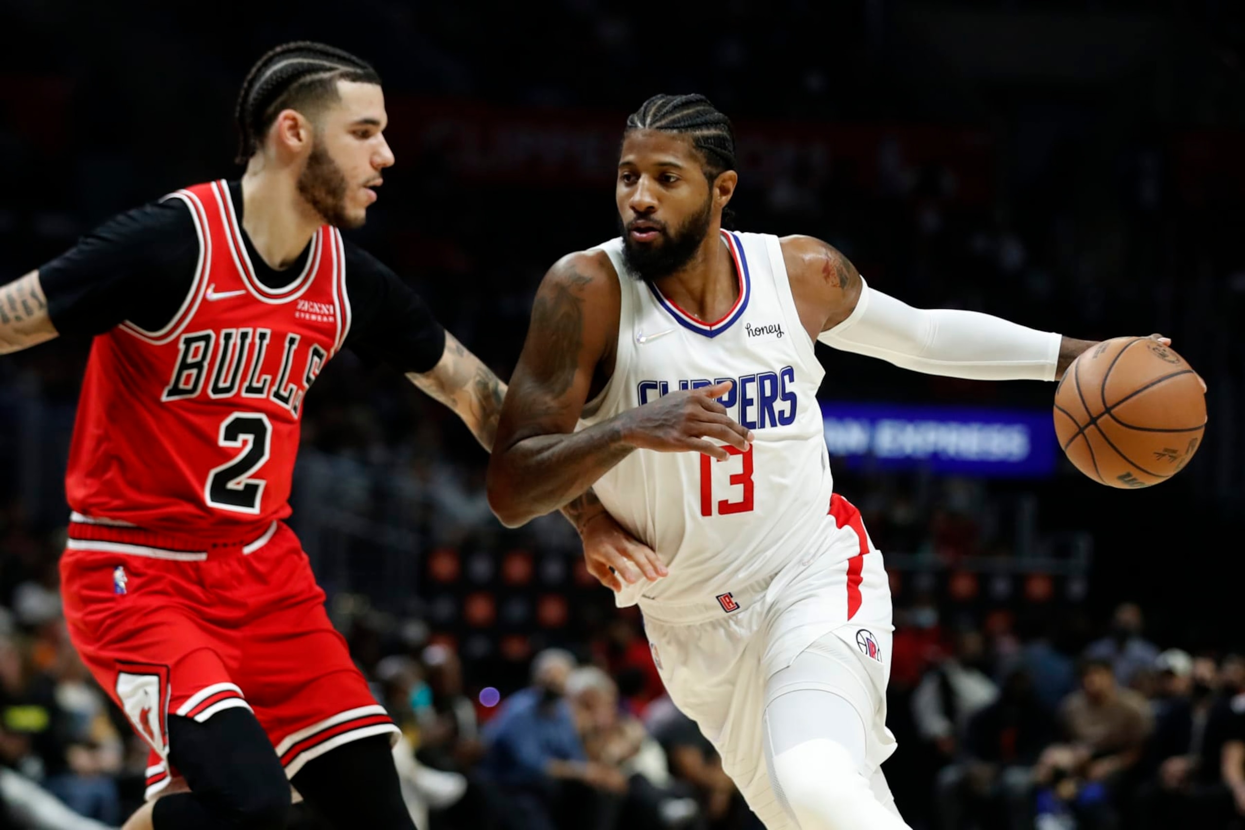 Los Angeles Clippers guard Paul George, right, drives to the basket against Chicago Bulls guard Lonzo Ball during the first half of an NBA basketball game Sunday, Nov. 14, 2021, in Los Angeles. (AP Photo/Alex Gallardo)