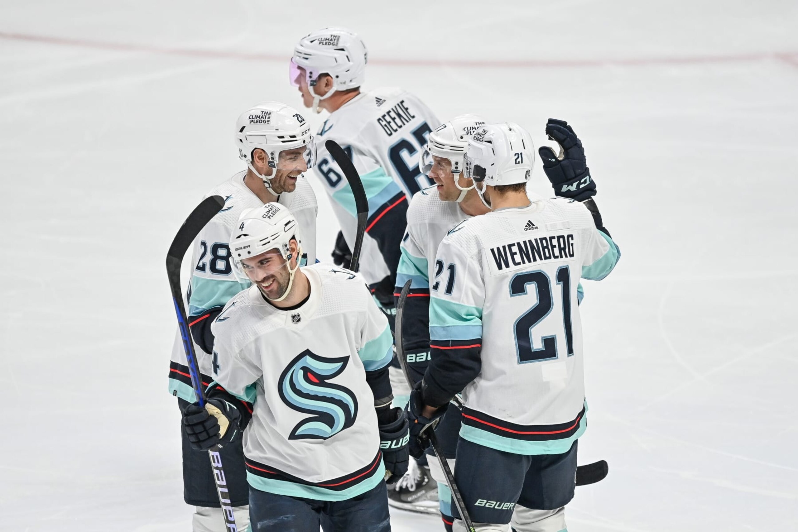 DENVER, COLORADO - APRIL 18:  Seattle Kraken players, including Carson Soucy #28, Justin Schultz #4, Jaden Schwartz #17 and Alex Wennberg #21 celebrate after a goal against the Colorado Avalanche by Morgan Geekie #67 in the third period of Game One in the First Round of the 2023 Stanley Cup Playoffs at Ball Arena on April 18, 2023 in Denver, Colorado. (Photo by Dustin Bradford/Getty Images)