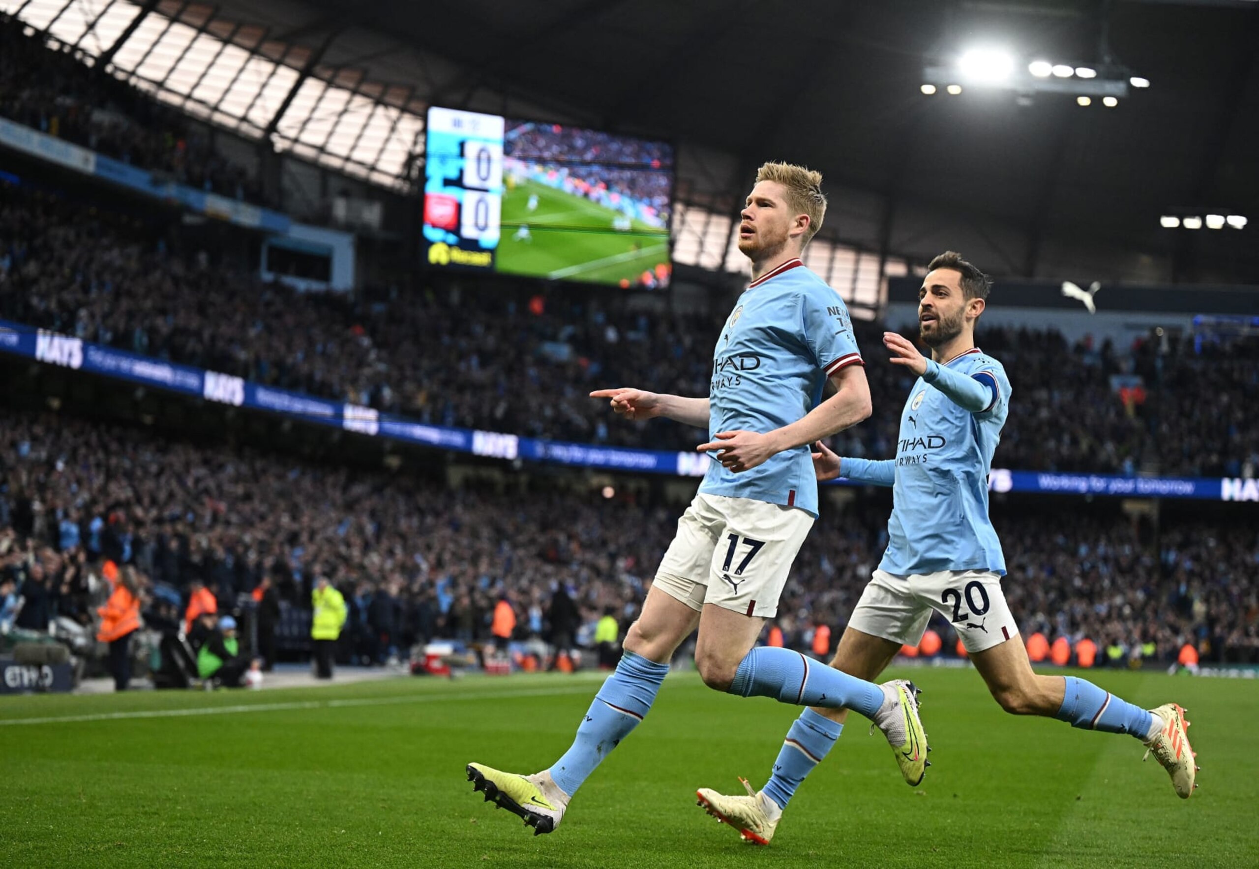 Manchester City's Belgian midfielder Kevin De Bruyne (L) celebrates scoring the opening goal during the English Premier League football match between Manchester City and Arsenal at the Etihad Stadium in Manchester, north west England, on April 26, 2023. (Photo by Oli SCARFF / AFP) / RESTRICTED TO EDITORIAL USE. No use with unauthorized audio, video, data, fixture lists, club/league logos or 'live' services. Online in-match use limited to 120 images. An additional 40 images may be used in extra time. No video emulation. Social media in-match use limited to 120 images. An additional 40 images may be used in extra time. No use in betting publications, games or single club/league/player publications. /  (Photo by OLI SCARFF/AFP via Getty Images)