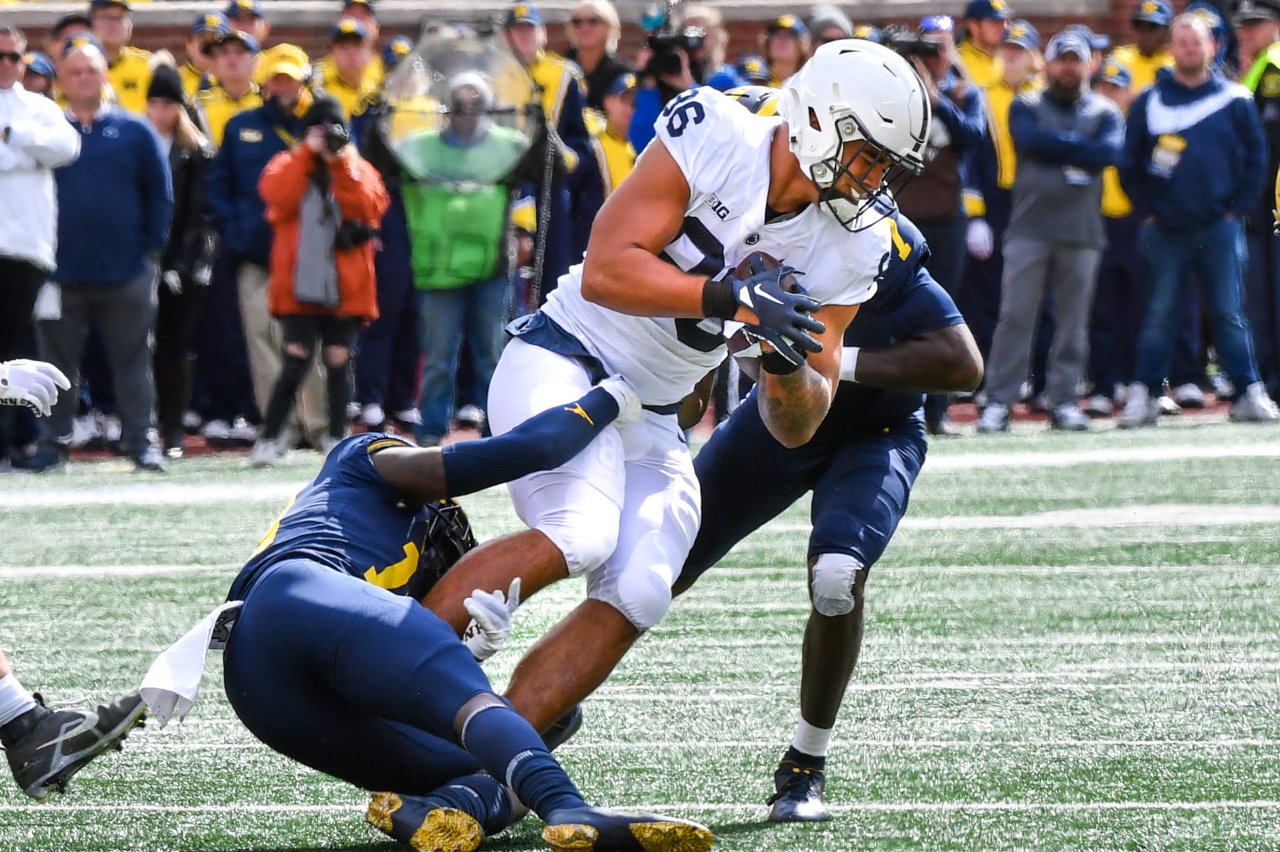 ANN ARBOR, MICHIGAN - OCTOBER 15: Brenton Strange #86 of the Penn State Nittany Lions fights for extra yards against Rod Moore #19 and Makari Paige #7 of the Michigan Wolverines during the first half of a college football game at Michigan Stadium on October 15, 2022 in Ann Arbor, Michigan. (Photo by Aaron J. Thornton/Getty Images)