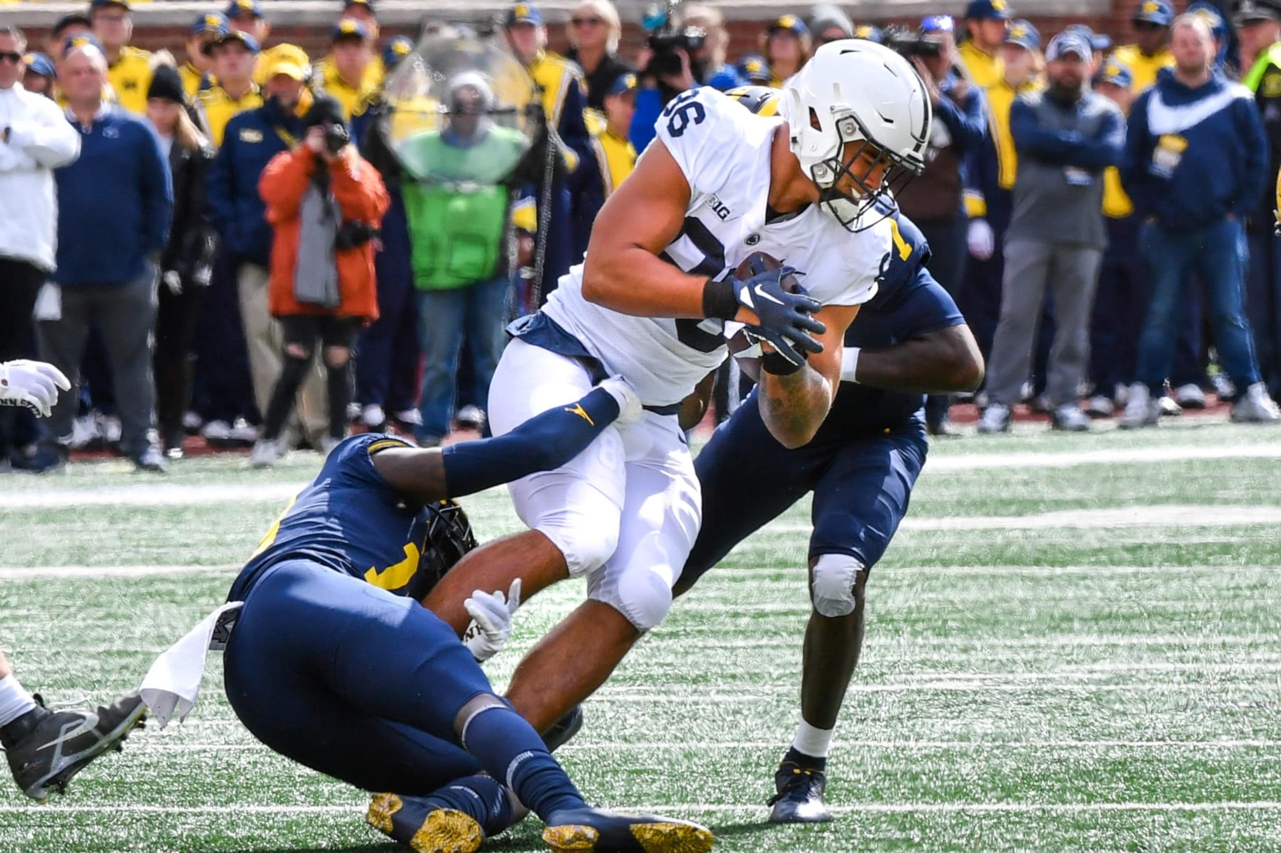 ANN ARBOR, MICHIGAN - OCTOBER 15: Brenton Strange #86 of the Penn State Nittany Lions fights for extra yards against Rod Moore #19 and Makari Paige #7 of the Michigan Wolverines during the first half of a college football game at Michigan Stadium on October 15, 2022 in Ann Arbor, Michigan. (Photo by Aaron J. Thornton/Getty Images)