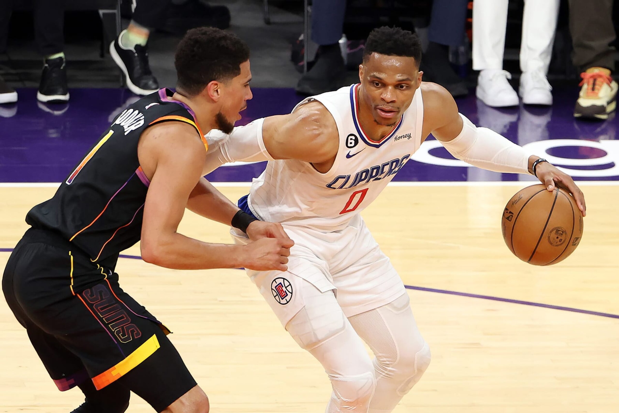PHOENIX, ARIZONA - APRIL 25: Russell Westbrook #0 of the LA Clippers dribbles against Devin Booker #1 of the Phoenix Suns during the first quarter in game five of the Western Conference First Round Playoffs at Footprint Center on April 25, 2023 in Phoenix, Arizona. NOTE TO USER: User expressly acknowledges and agrees that, by downloading and or using this photograph, User is consenting to the terms and conditions of the Getty Images License Agreement. (Photo by Christian Petersen/Getty Images)