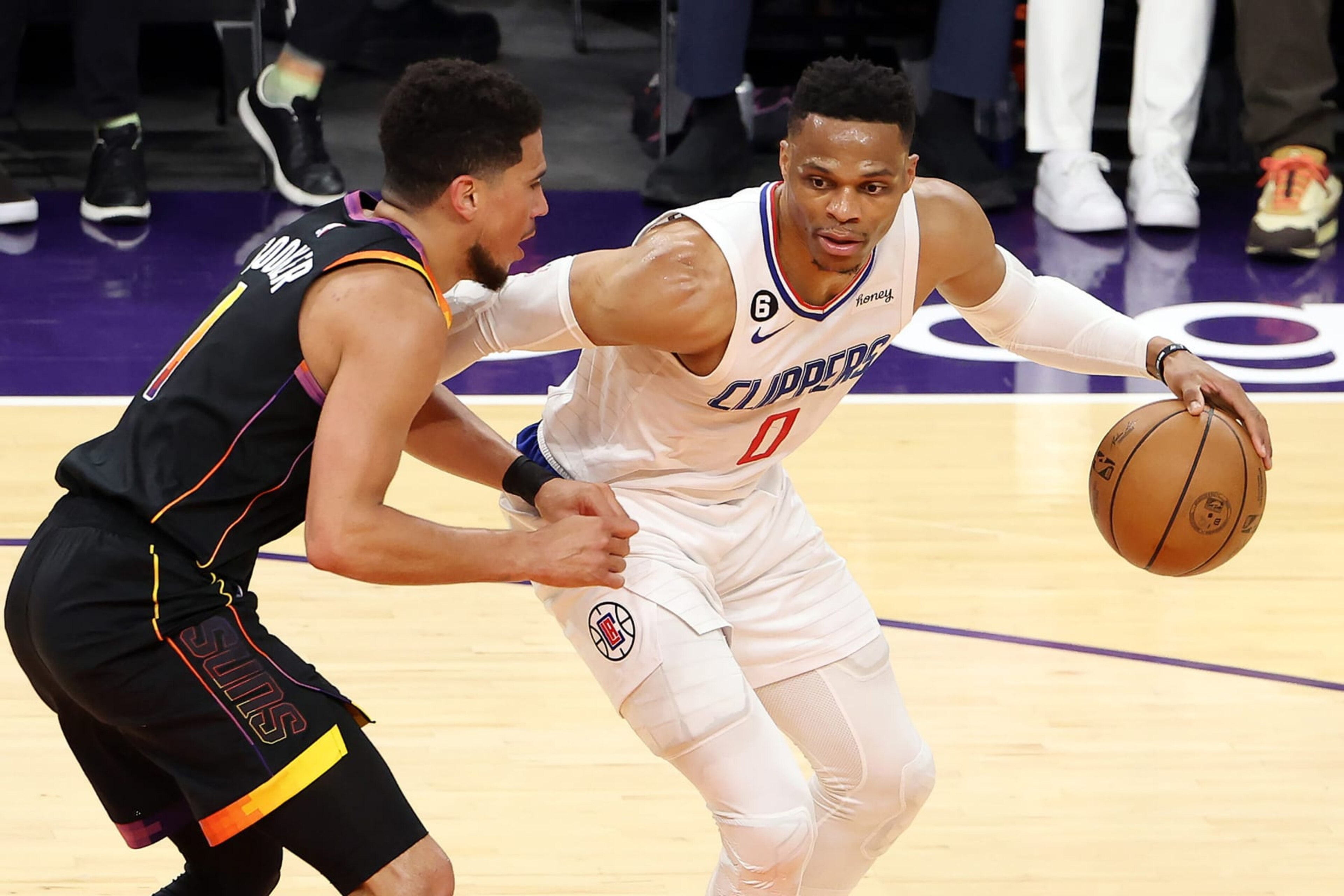 PHOENIX, ARIZONA - APRIL 25: Russell Westbrook #0 of the LA Clippers dribbles against Devin Booker #1 of the Phoenix Suns during the first quarter in game five of the Western Conference First Round Playoffs at Footprint Center on April 25, 2023 in Phoenix, Arizona. NOTE TO USER: User expressly acknowledges and agrees that, by downloading and or using this photograph, User is consenting to the terms and conditions of the Getty Images License Agreement. (Photo by Christian Petersen/Getty Images)