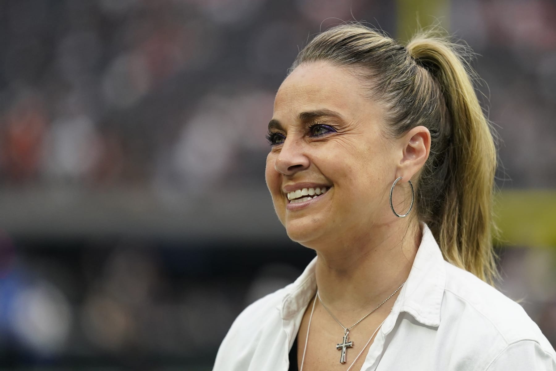 Las Vegas Aces coach Becky Hammon stands on the field before of an NFL football game between the Denver Broncos and Las Vegas Raiders, Sunday, Oct. 2, 2022 in Las Vegas. (AP Photo/Abbie Parr)