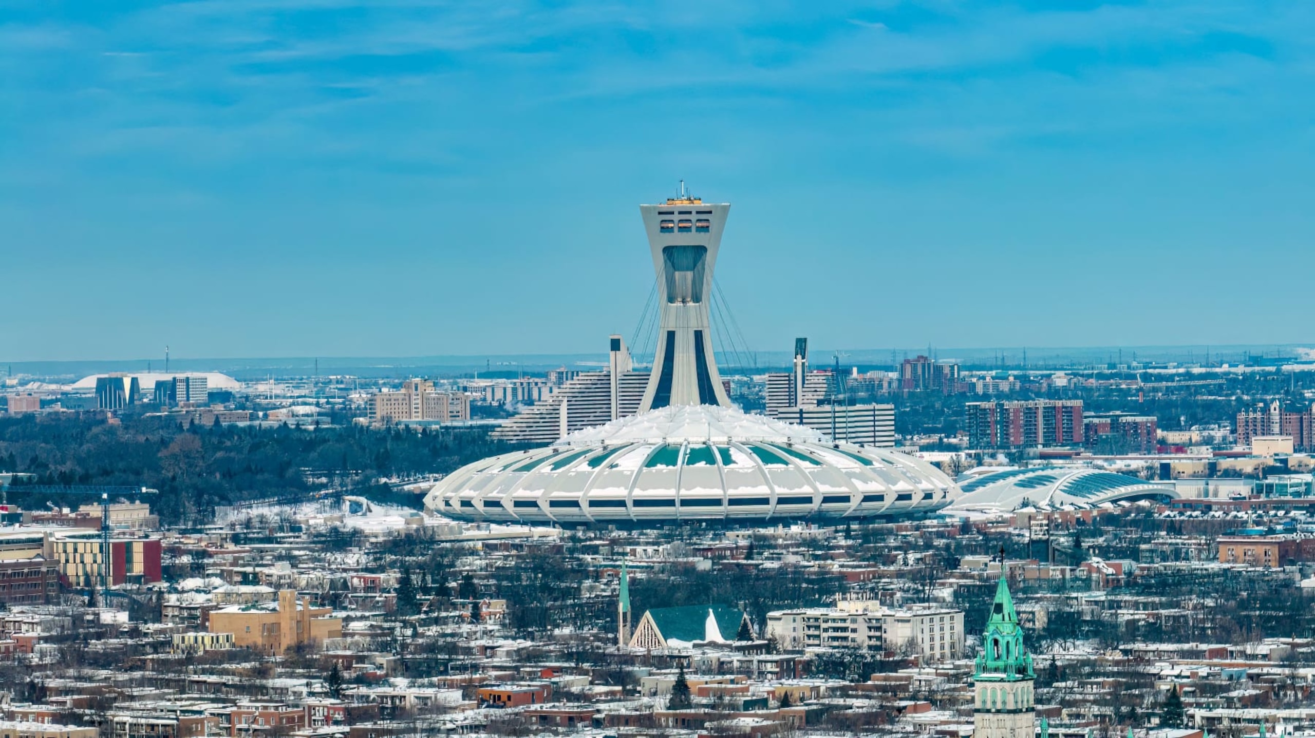 A general view shows the Olympic Stadium in Montreal, Quebec, Canada, on February 7, 2023. - In the mostly French-speaking metropolis of Montreal, more and more people get around by bike, even in sometimes extreme weather conditions. And on this city's bike paths, it is not uncommon to come across young 'uns riding on a child seat in the back, bundled up as though ready for skiing, on their way to school or daycare. They are quickly outpacing families who opt to pull kids in toboggans on sidewalks after a storm. In just a few years, as in other cities around the world, the number and length of bike paths have exploded in Montreal, making it one of the most cyclable in North America. (Photo by Sebastien ST-JEAN / AFP) (Photo by SEBASTIEN ST-JEAN/AFP via Getty Images)
