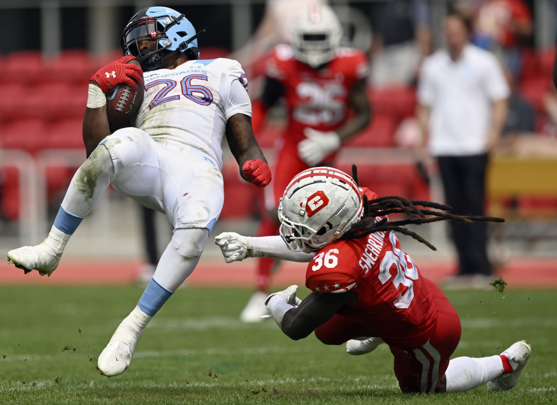 WASHINGTON, DC - APRIL 16: Arlington's Leddie Brown, (26) left, is upended by Defenders safety D.J. Swearinger (36) during the DC Defenders defeat of the Arlington Renegades 28-26 in XFL football on April 16, 2023 at Audi Field in Washington, DC. (Photo by John McDonnell/The Washington Post via Getty Images)