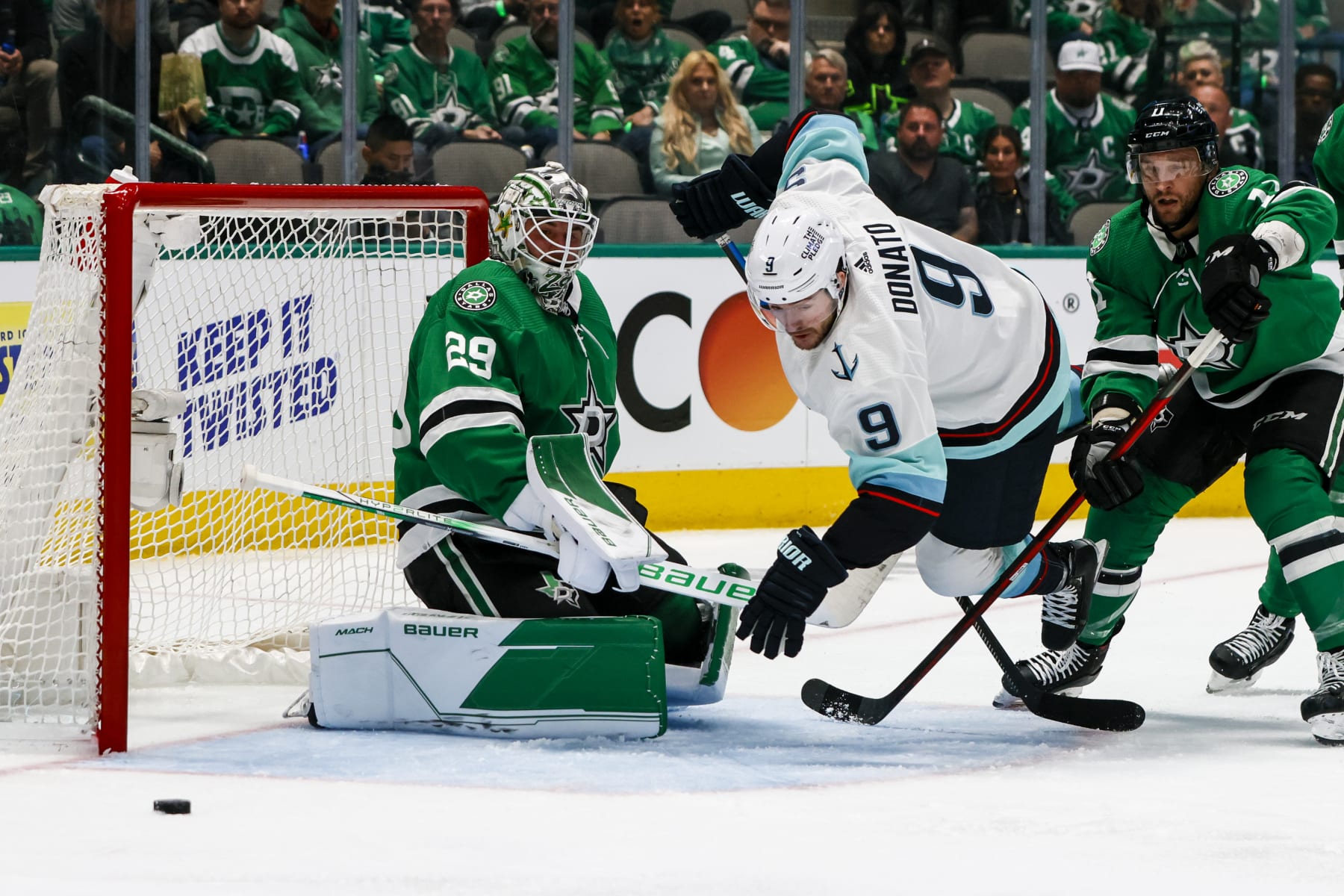 DALLAS, TX - MAY 02: Seattle Kraken center Ryan Donato (9) tries to poke the puck past Dallas Stars goaltender Jake Oettinger (29) with help from center Luke Glendening (11)  during the game between the Dallas Stars and the Seattle Kraken on May 2, 2023 at American Airlines Center in Dallas, Texas. (Photo by Matthew Pearce/Icon Sportswire via Getty Images)