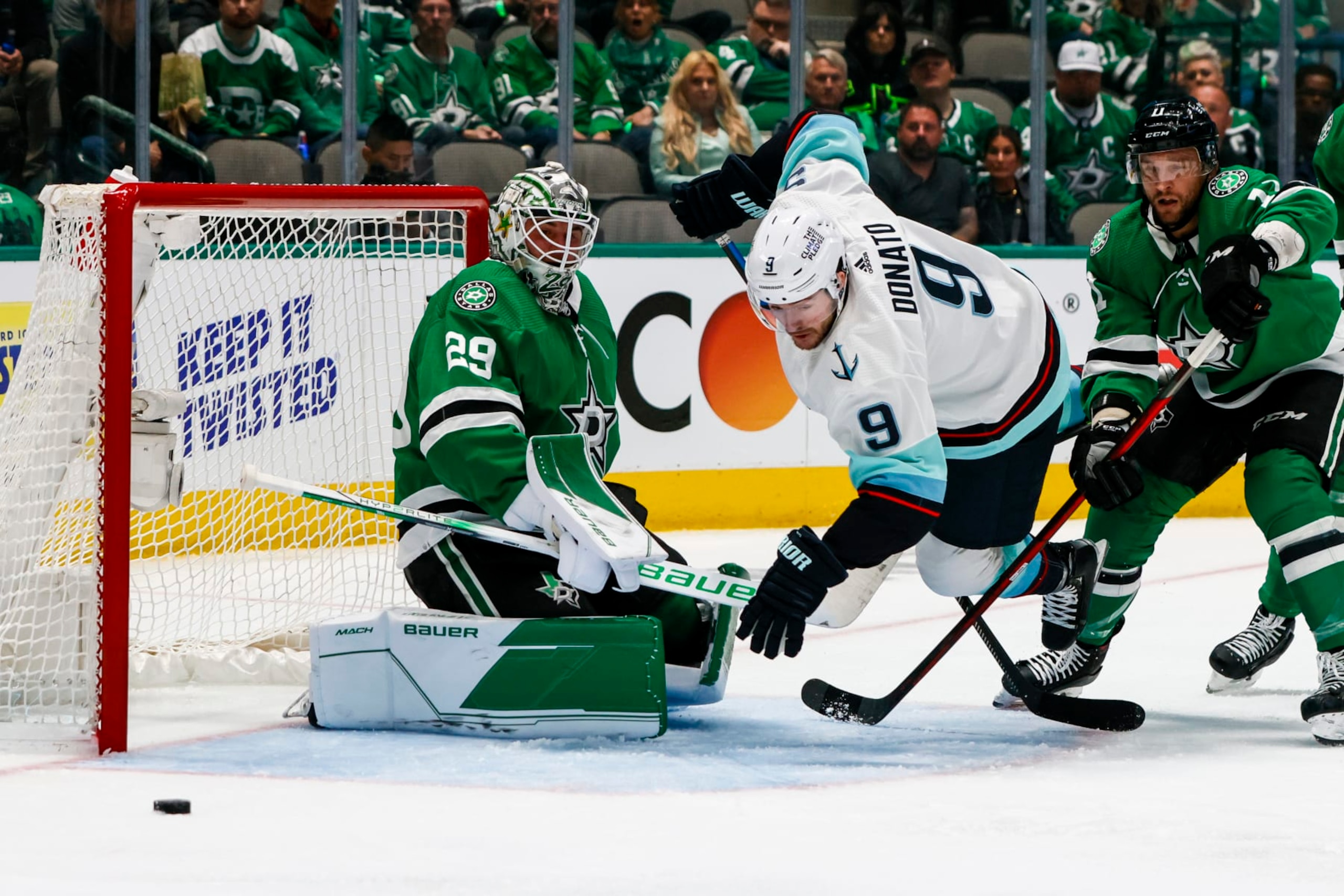 DALLAS, TX - MAY 02: Seattle Kraken center Ryan Donato (9) tries to poke the puck past Dallas Stars goaltender Jake Oettinger (29) with help from center Luke Glendening (11)  during the game between the Dallas Stars and the Seattle Kraken on May 2, 2023 at American Airlines Center in Dallas, Texas. (Photo by Matthew Pearce/Icon Sportswire via Getty Images)