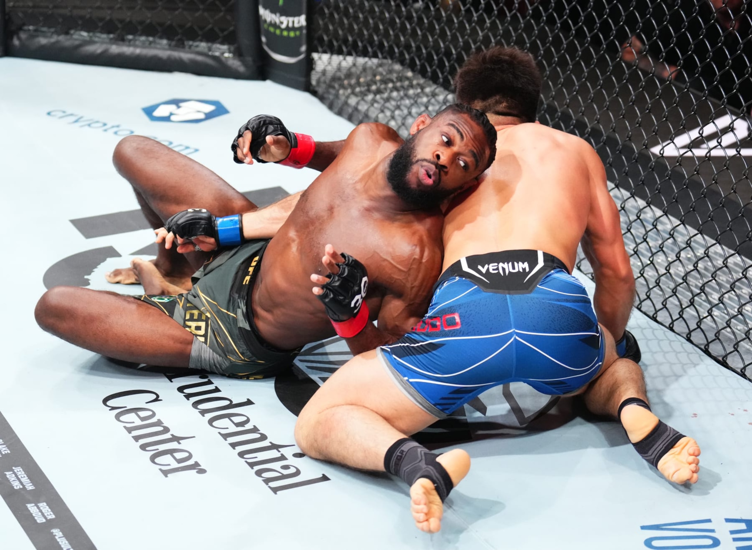 Aljamain Sterling and Henry Cejudo scramble on the canvas.