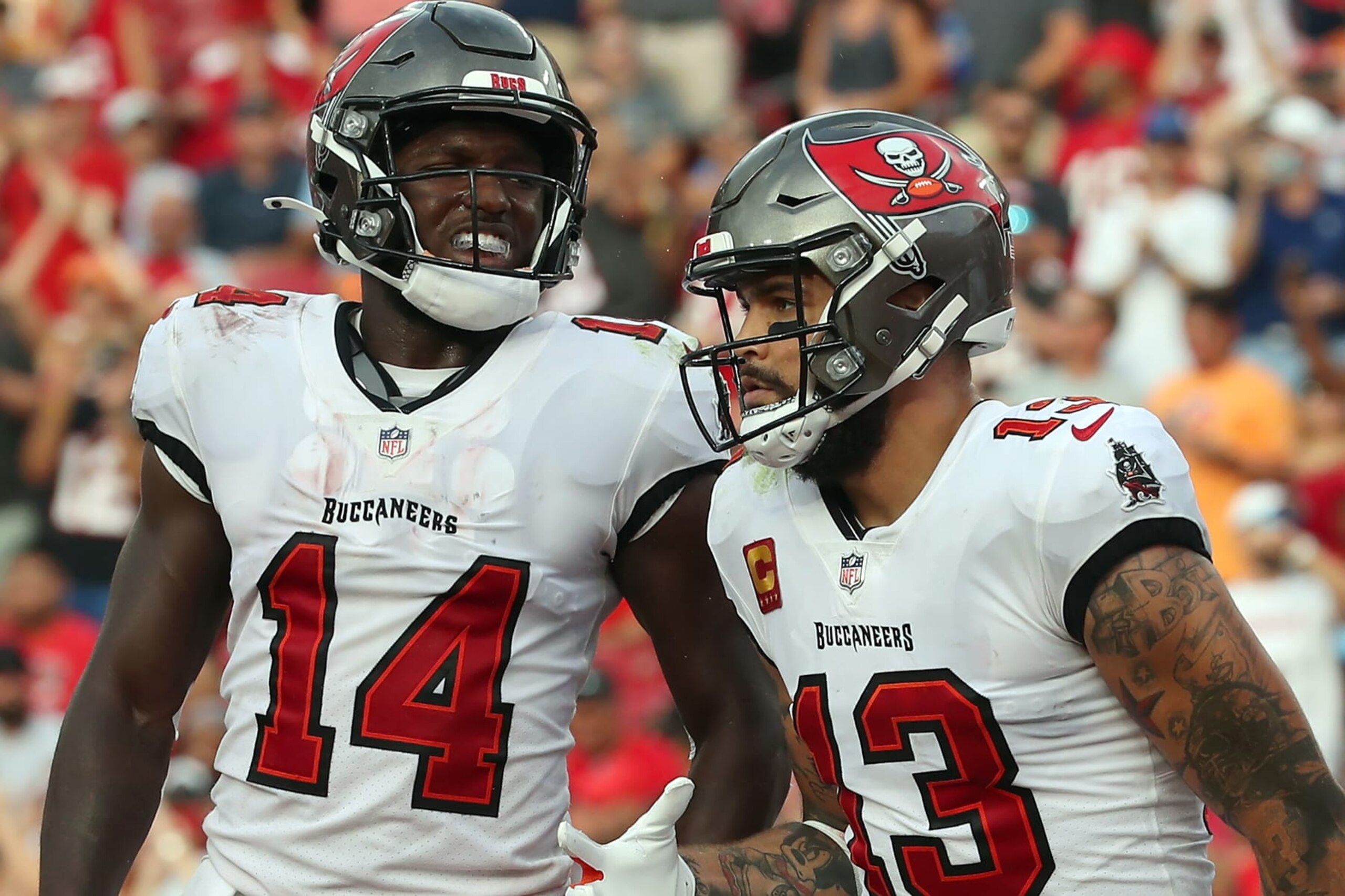 TAMPA, FL - SEPTEMBER 19: Tampa Bay Buccaneers Wide Receiver Chris Godwin (14) and Wide Receiver Mike Evans (13) trot back to the sidelines after Evans scored a touchdown during the regular season game between the Atlanta Falcons and the Tampa Bay Buccaneers on September 19, 2021 at Raymond James Stadium in Tampa, Florida. (Photo by Cliff Welch/Icon Sportswire via Getty Images)