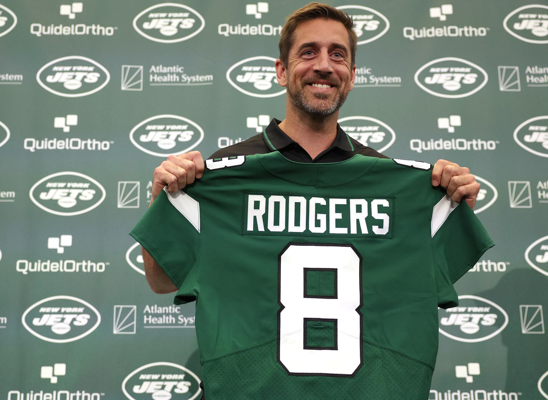 FLORHAM PARK, NEW JERSEY - APRIL 26: New York Jets quarterback Aaron Rodgers poses with a jersey during an introductory press conference at Atlantic Health Jets Training Center on April 26, 2023 in Florham Park, New Jersey. (Photo by Elsa/Getty Images)