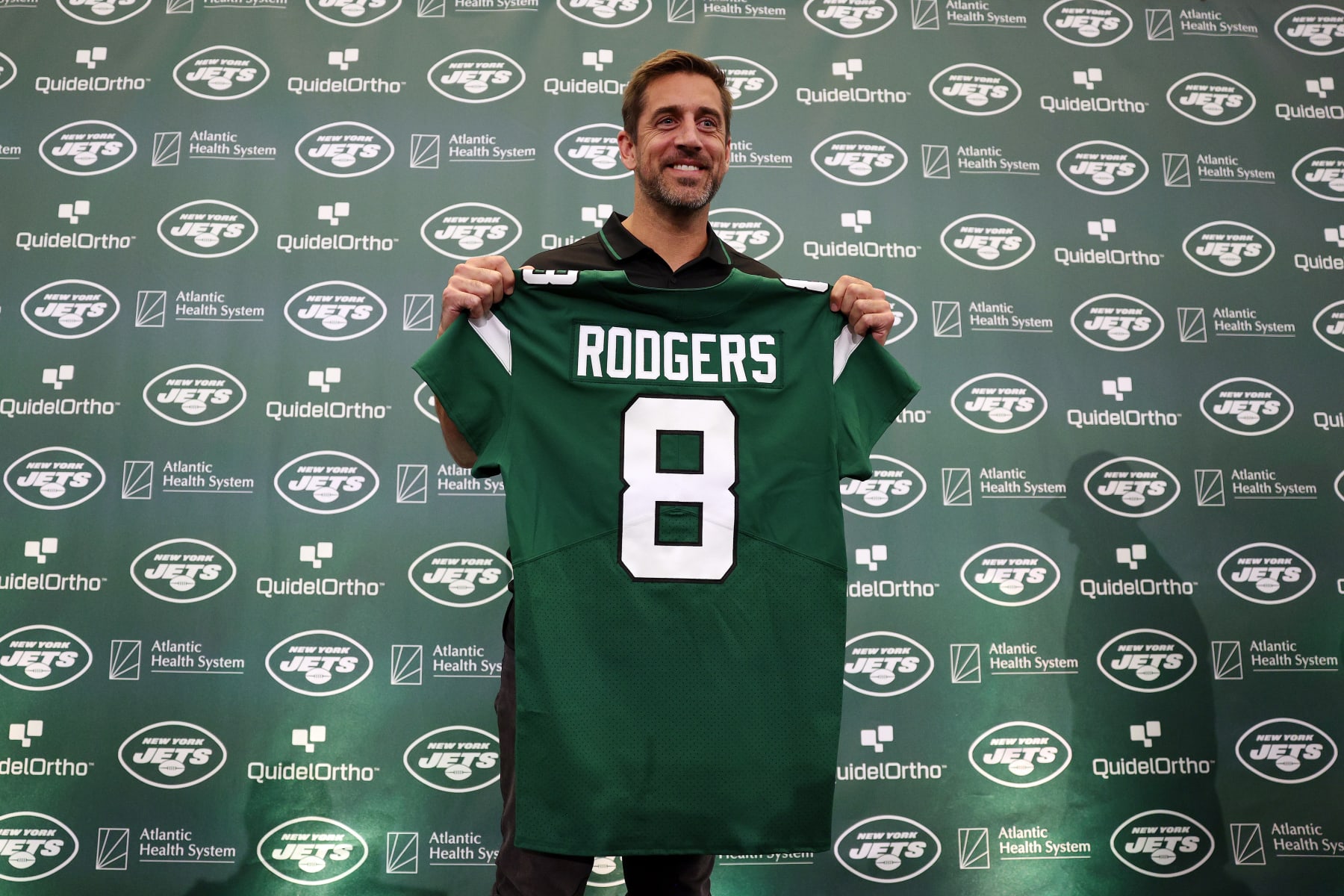 FLORHAM PARK, NEW JERSEY - APRIL 26: New York Jets quarterback Aaron Rodgers poses with a jersey during an introductory press conference at Atlantic Health Jets Training Center on April 26, 2023 in Florham Park, New Jersey. (Photo by Elsa/Getty Images)
