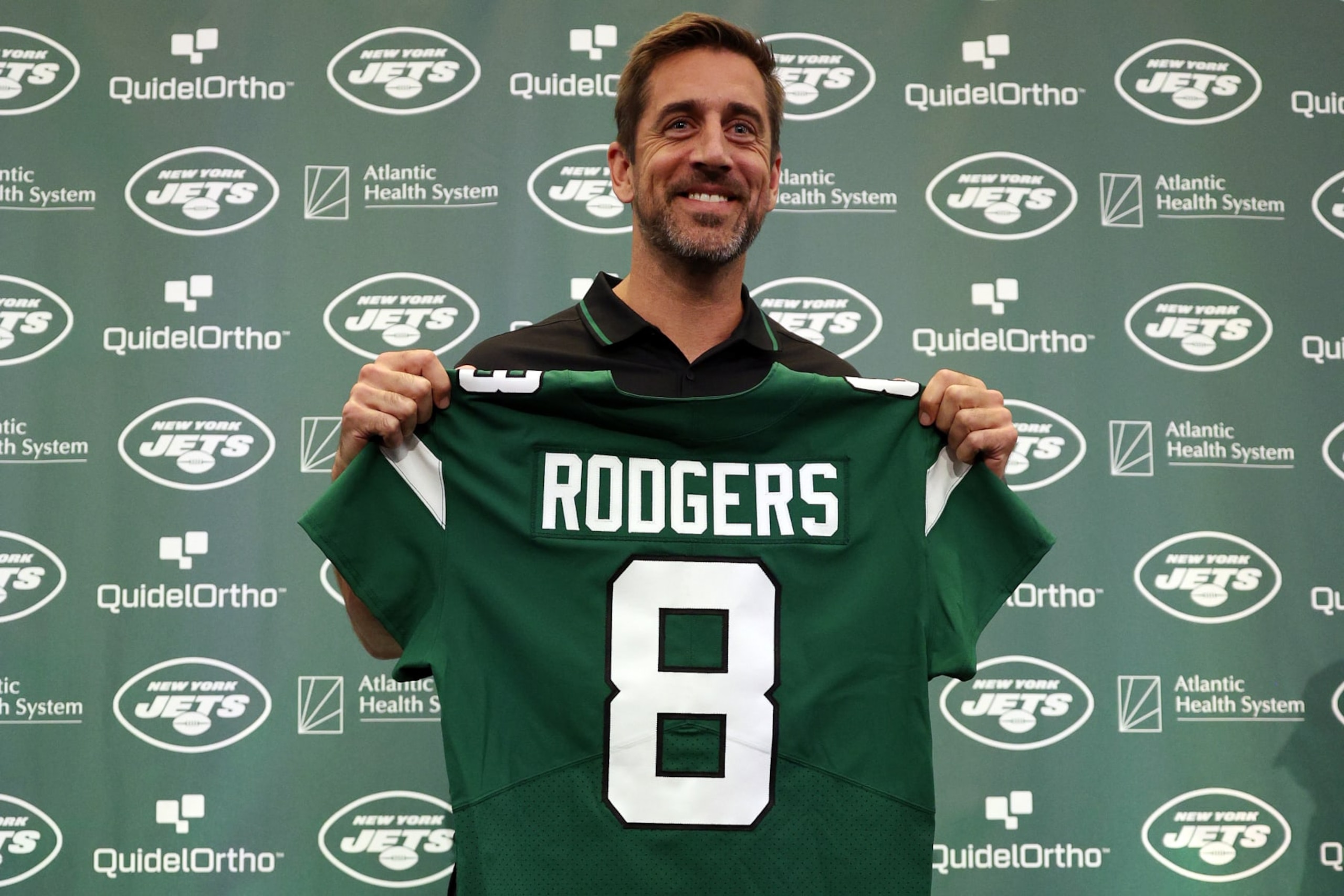 FLORHAM PARK, NEW JERSEY - APRIL 26: New York Jets quarterback Aaron Rodgers poses with a jersey during an introductory press conference at Atlantic Health Jets Training Center on April 26, 2023 in Florham Park, New Jersey. (Photo by Elsa/Getty Images)