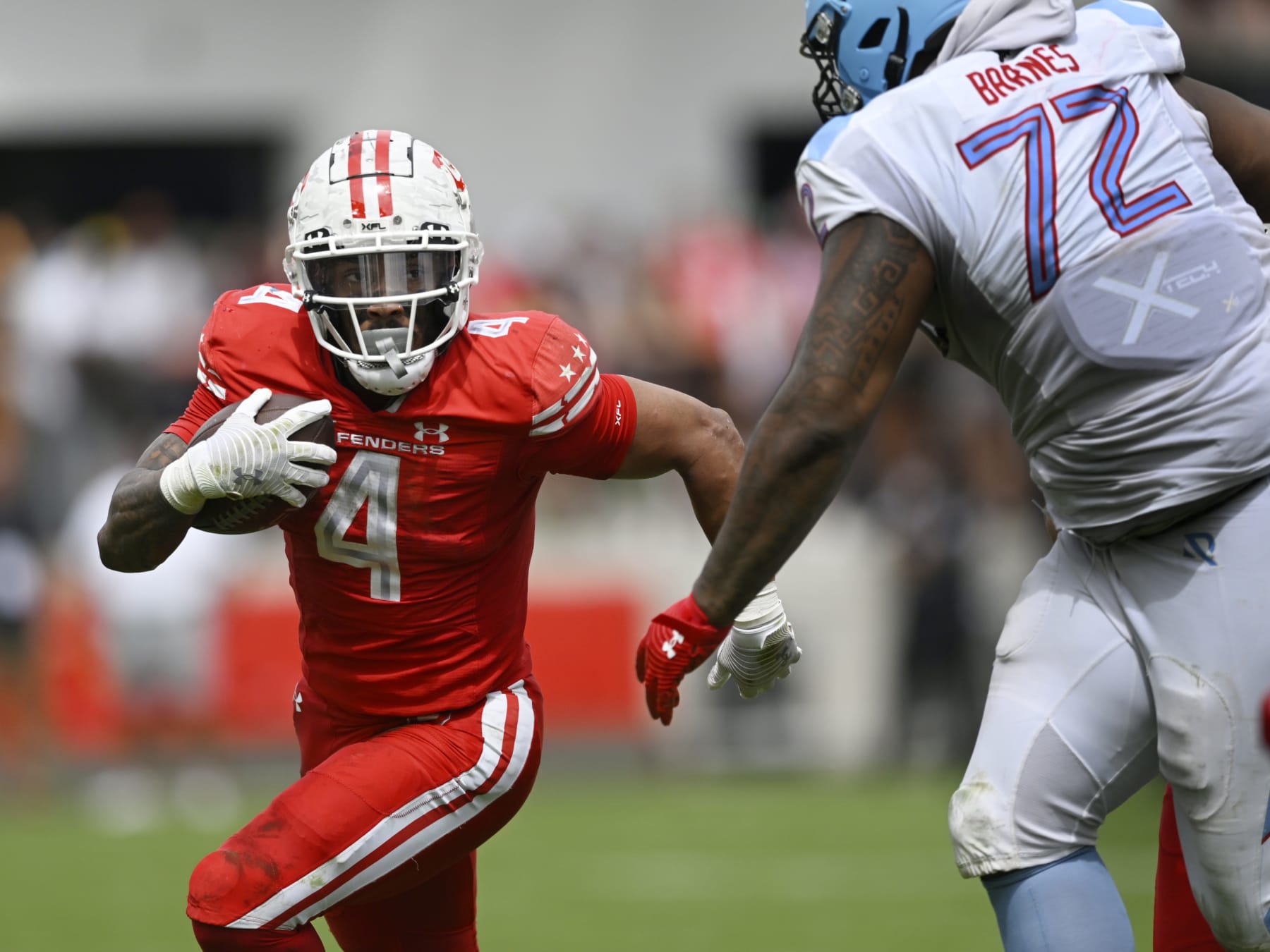 WASHINGTON, DC - APRIL 16: D.C. Defenders running back Abram Smith #4, left, runs agfainst Arlington's T.J. Barnes during the DC Defenders defeat of the Arlington Renegades 28-26 in XFL football on April 16, 2023 at Audi Field in Washington, DC. (Photo by John McDonnell/The Washington Post via Getty Images)