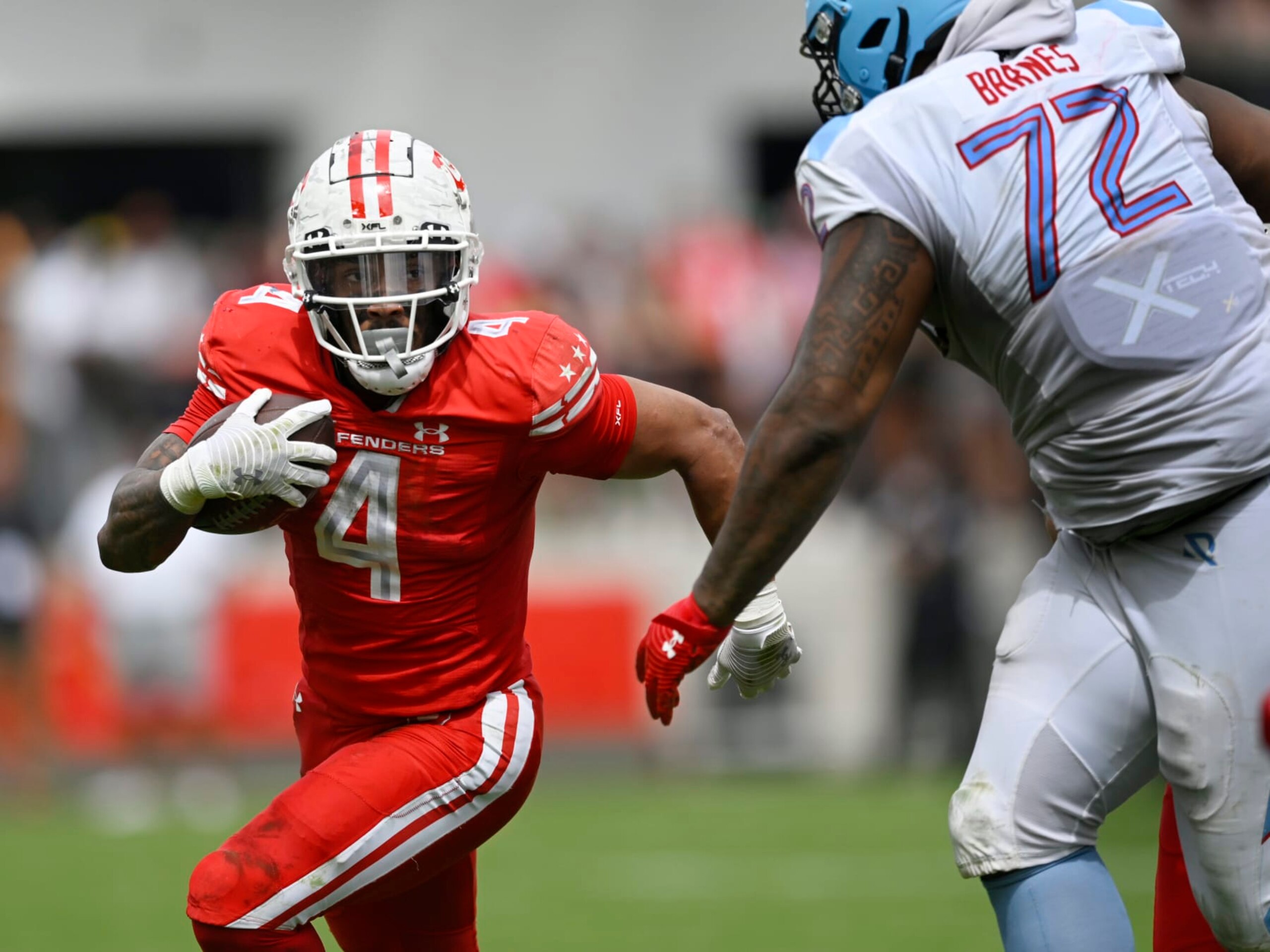 WASHINGTON, DC - APRIL 16: D.C. Defenders running back Abram Smith #4, left, runs agfainst Arlington's T.J. Barnes during the DC Defenders defeat of the Arlington Renegades 28-26 in XFL football on April 16, 2023 at Audi Field in Washington, DC. (Photo by John McDonnell/The Washington Post via Getty Images)