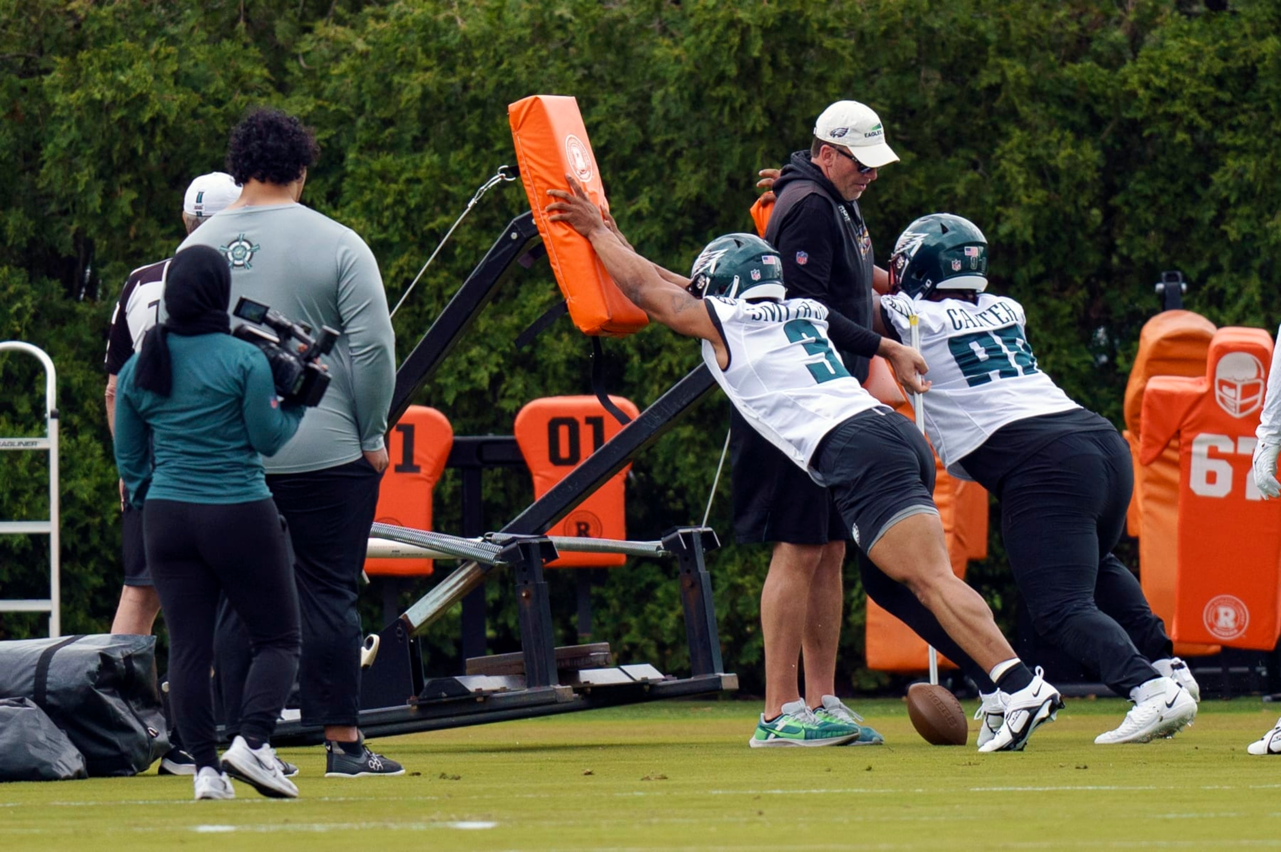 Philadelphia Eagles' Nolan Smith, center, and Jalen Carter, right, runs a drill during NFL rookie football minicamp, Friday, May 5, 2023, in Philadelphia. (AP Photo/Chris Szagola)