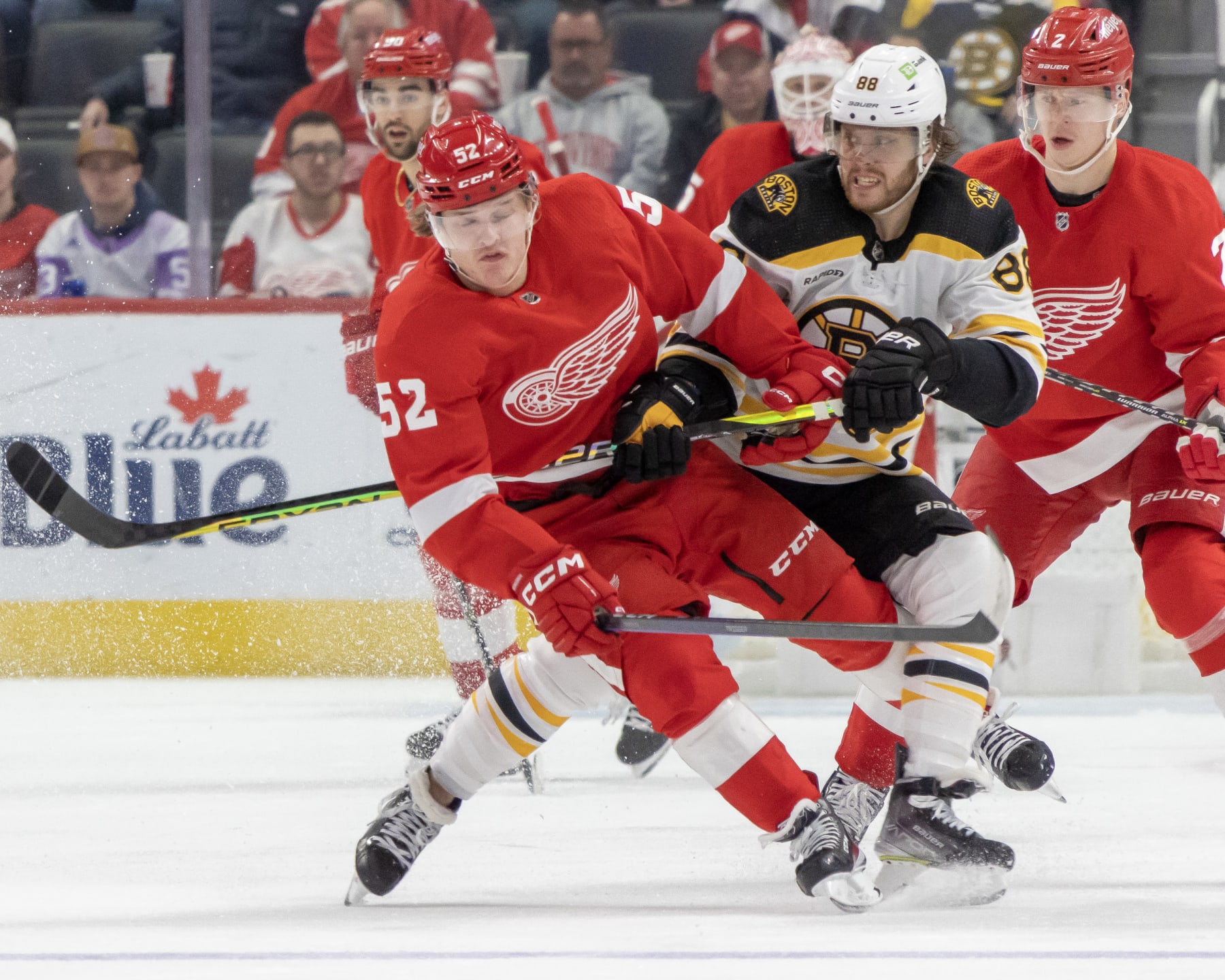 DETROIT, MI - MARCH 12: David Pastrnak #88 of the Boston Bruins body checks Jonatan Berggren #52 of the Detroit Red Wings during the third period of an NHL game at Little Caesars Arena on March 12, 2023 in Detroit, Michigan. Detroit defeated Boston 5-3. (Photo by Dave Reginek/NHLI via Getty Images)