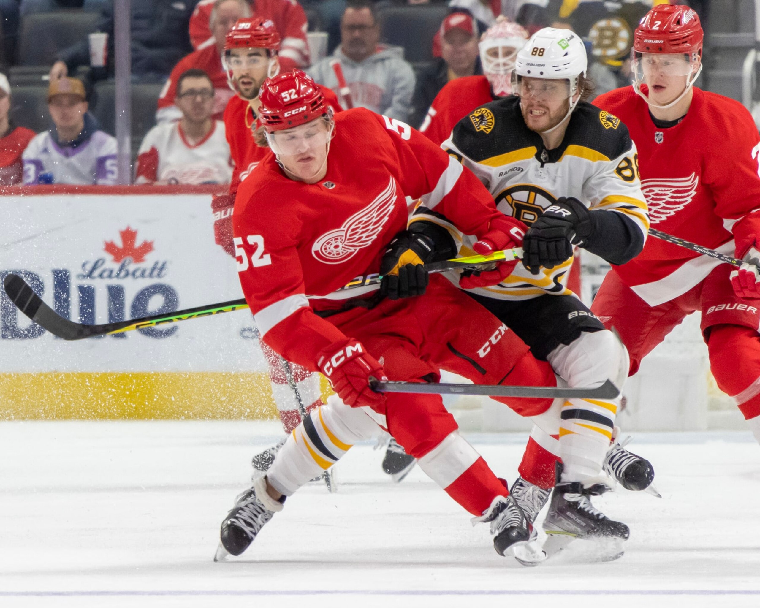 DETROIT, MI - MARCH 12: David Pastrnak #88 of the Boston Bruins body checks Jonatan Berggren #52 of the Detroit Red Wings during the third period of an NHL game at Little Caesars Arena on March 12, 2023 in Detroit, Michigan. Detroit defeated Boston 5-3. (Photo by Dave Reginek/NHLI via Getty Images)