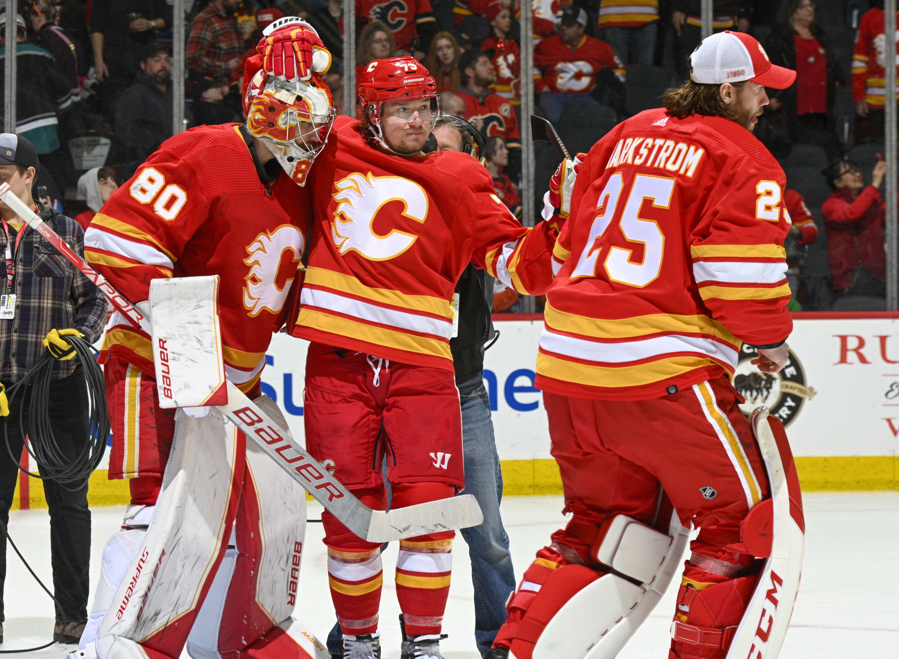 CALGARY, ALBERTA - APRIL 02: Dan Vladar #80, Jacob Markstrom #25 and Tyler Toffoli #73 of the Calgary Flames celebrate after a win against the Anaheim Ducks at Scotiabank Saddledome on April 02, 2023 in Calgary, Alberta. (Photo by Terence Leung/NHLI via Getty Images)