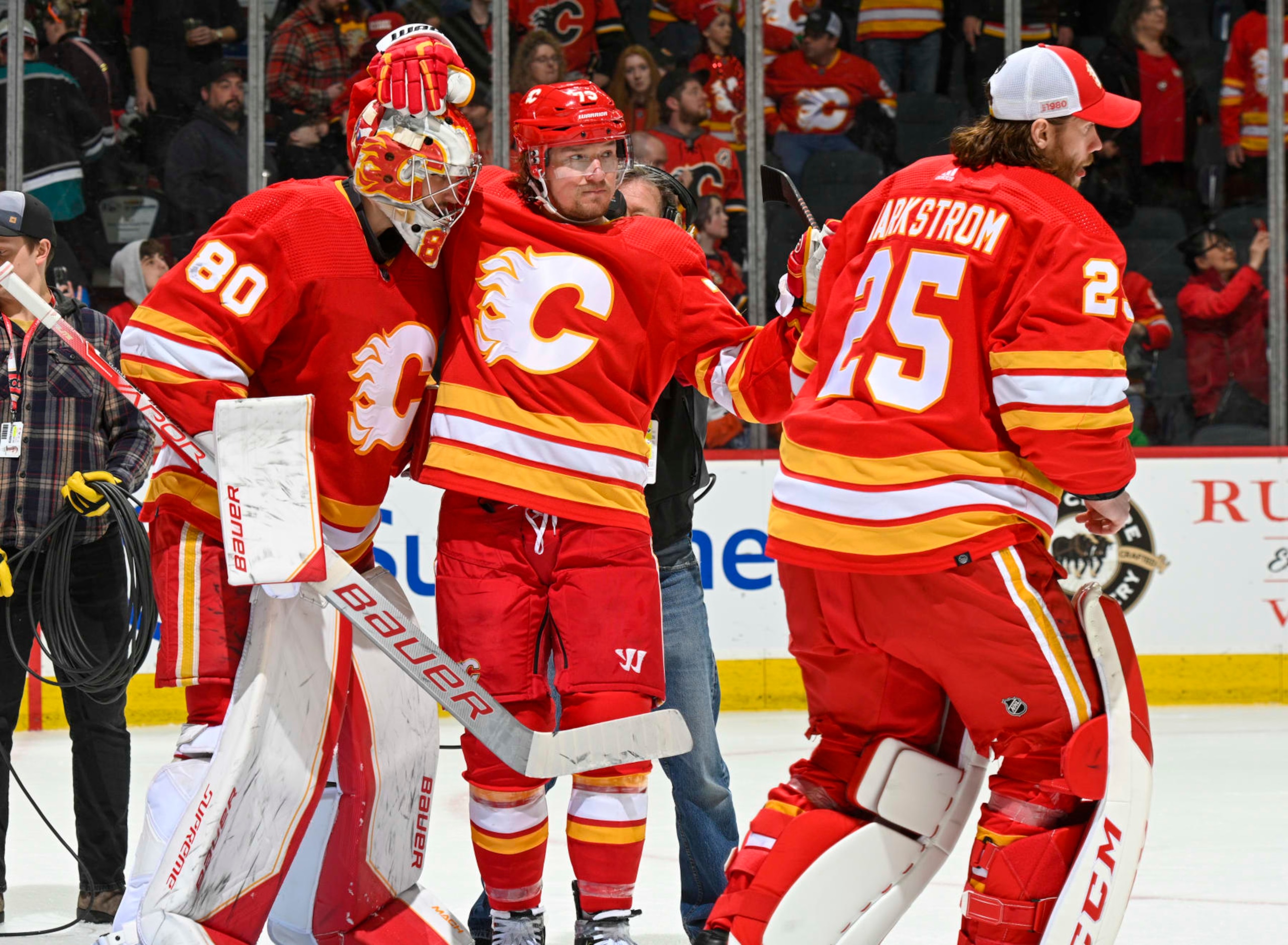 CALGARY, ALBERTA - APRIL 02: Dan Vladar #80, Jacob Markstrom #25 and Tyler Toffoli #73 of the Calgary Flames celebrate after a win against the Anaheim Ducks at Scotiabank Saddledome on April 02, 2023 in Calgary, Alberta. (Photo by Terence Leung/NHLI via Getty Images)