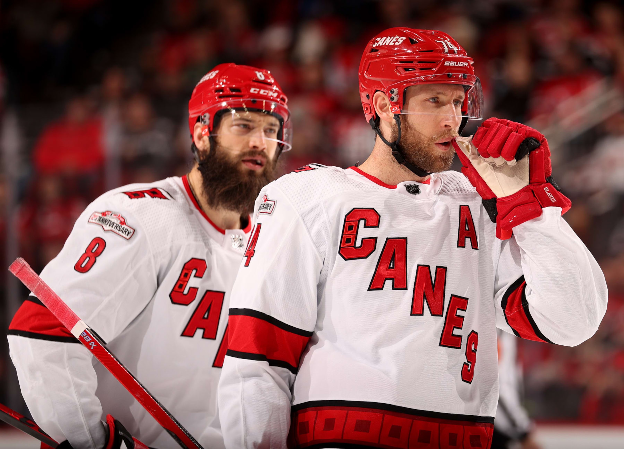 NEWARK, NEW JERSEY - MARCH 12: Jaccob Slavin #74 and Brent Burns #8 of the Carolina Hurricanes talk before a face off against the New Jersey Devils during the second period at Prudential Center on March 12, 2023 in Newark, New Jersey. (Photo by Elsa/Getty Images)