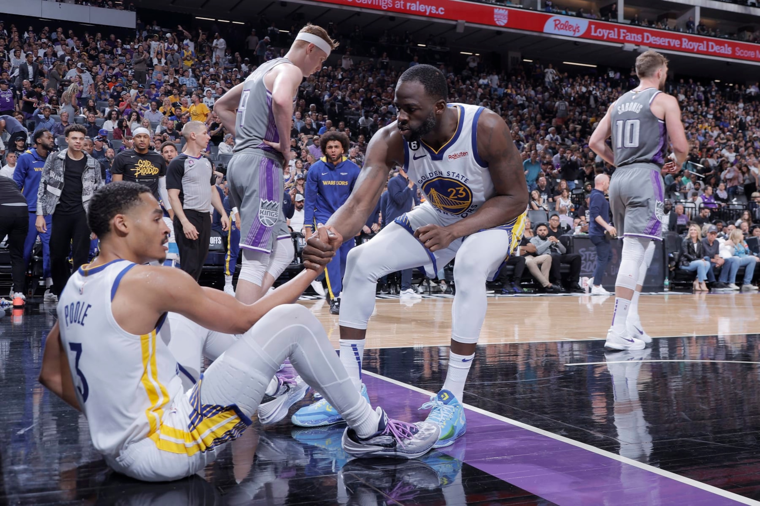 SACRAMENTO, CA - APRIL 26: Draymond Green #23 of the Golden State Warriors helps up Jordan Poole #3 during Round 1 Game 5 of the 2023 NBA Playoffs on April 26, 2023 at Golden 1 Center in SACRAMENTO, California. NOTE TO USER: User expressly acknowledges and agrees that, by downloading and or using this Photograph, user is consenting to the terms and conditions of the Getty Images License Agreement. Mandatory Copyright Notice: Copyright 2023 NBAE (Photo by Rocky Widner/NBAE via Getty Images)