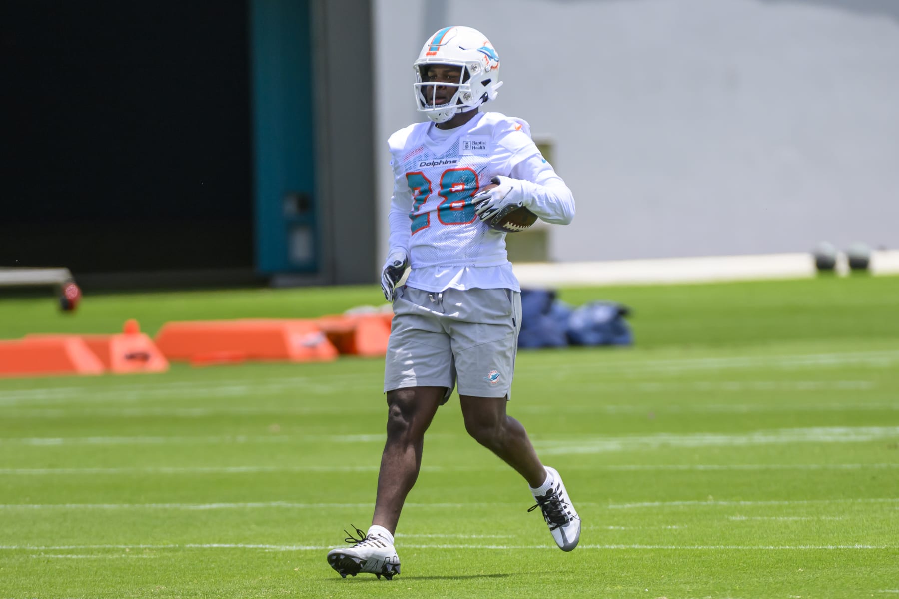 MIAMI GARDENS, FL - MAY 12: Miami Dolphins running back Devon Achane (28) runs with the ball on the field during the rookie minicamp at the Baptist Health Training Complex on May 12, 2023 in Miami Gardens, Florida. (Photo by Doug Murray/Icon Sportswire via Getty Images)