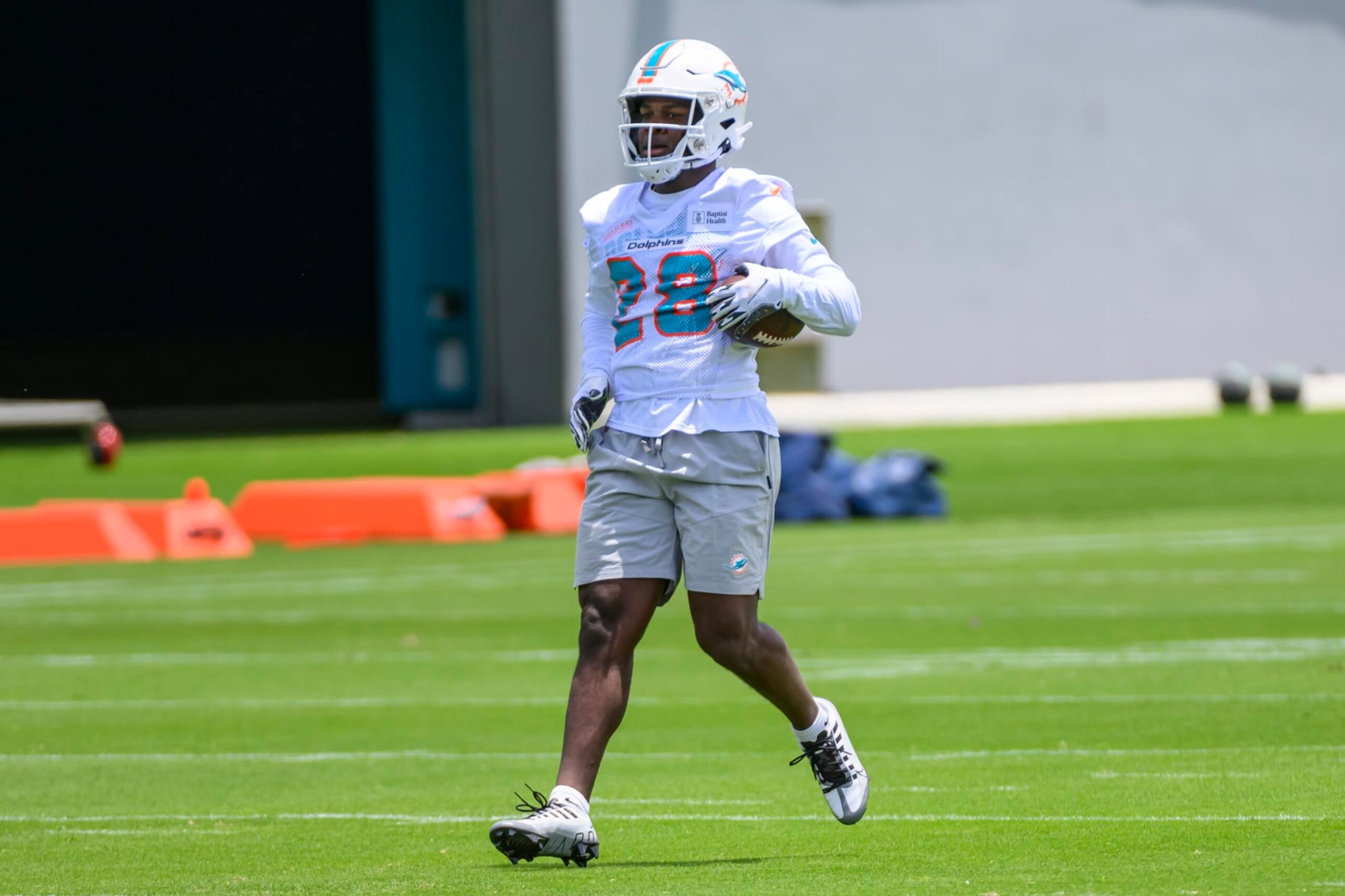 MIAMI GARDENS, FL - MAY 12: Miami Dolphins running back Devon Achane (28) runs with the ball on the field during the rookie minicamp at the Baptist Health Training Complex on May 12, 2023 in Miami Gardens, Florida. (Photo by Doug Murray/Icon Sportswire via Getty Images)