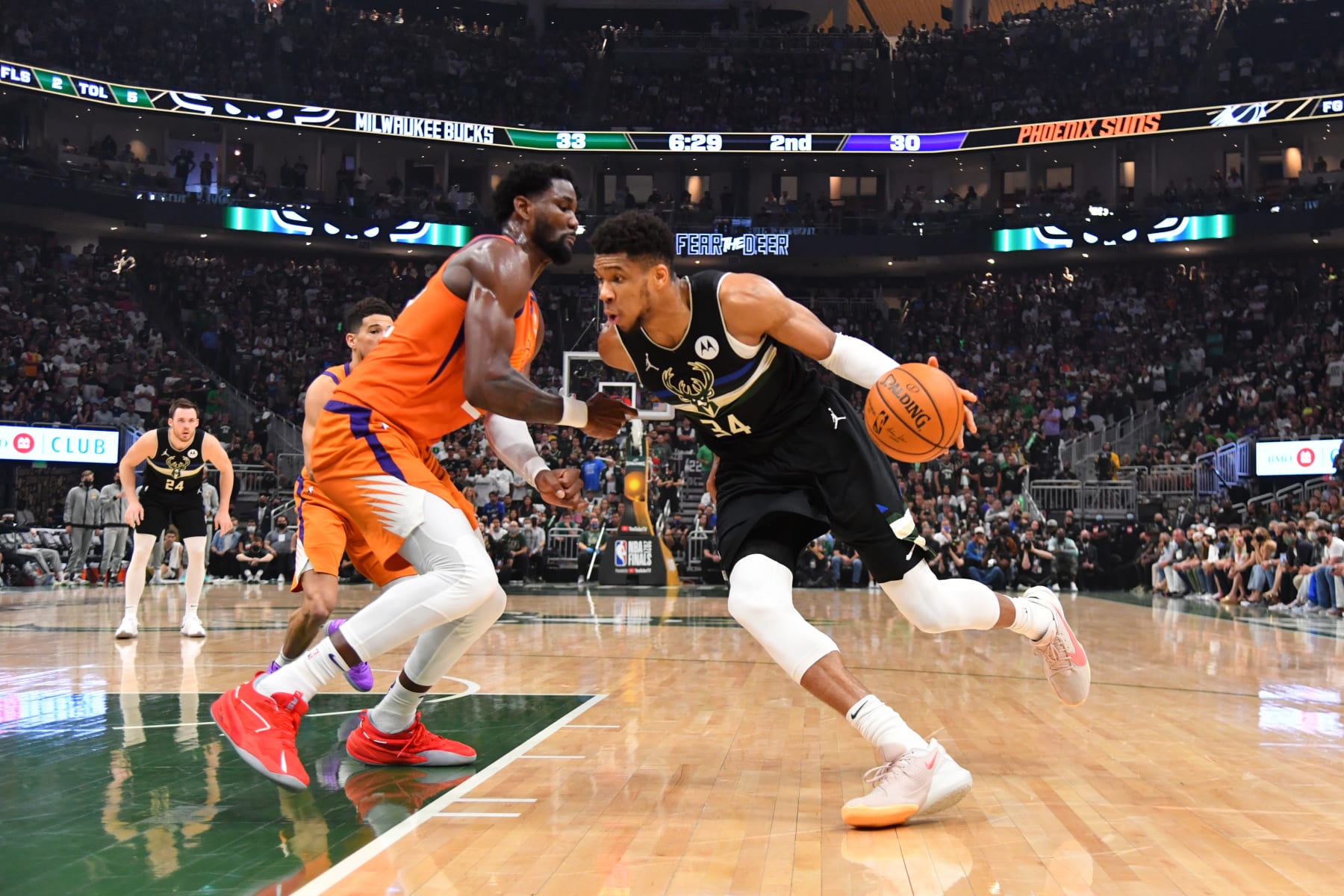 MILWAUKEE, WI - JULY 20: Giannis Antetokounmpo #34 of the Milwaukee Bucks handles the ball against Deandre Ayton #22 of the Phoenix Suns during Game Six of the 2021 NBA Finals on July 20, 2021 at Fiserv Forum in Milwaukee, Wisconsin. NOTE TO USER: User expressly acknowledges and agrees that, by downloading and/or using this Photograph, user is consenting to the terms and conditions of the Getty Images License Agreement. Mandatory Copyright Notice: Copyright 2021 NBAE (Photo by Jesse D. Garrabrant/NBAE via Getty Images)