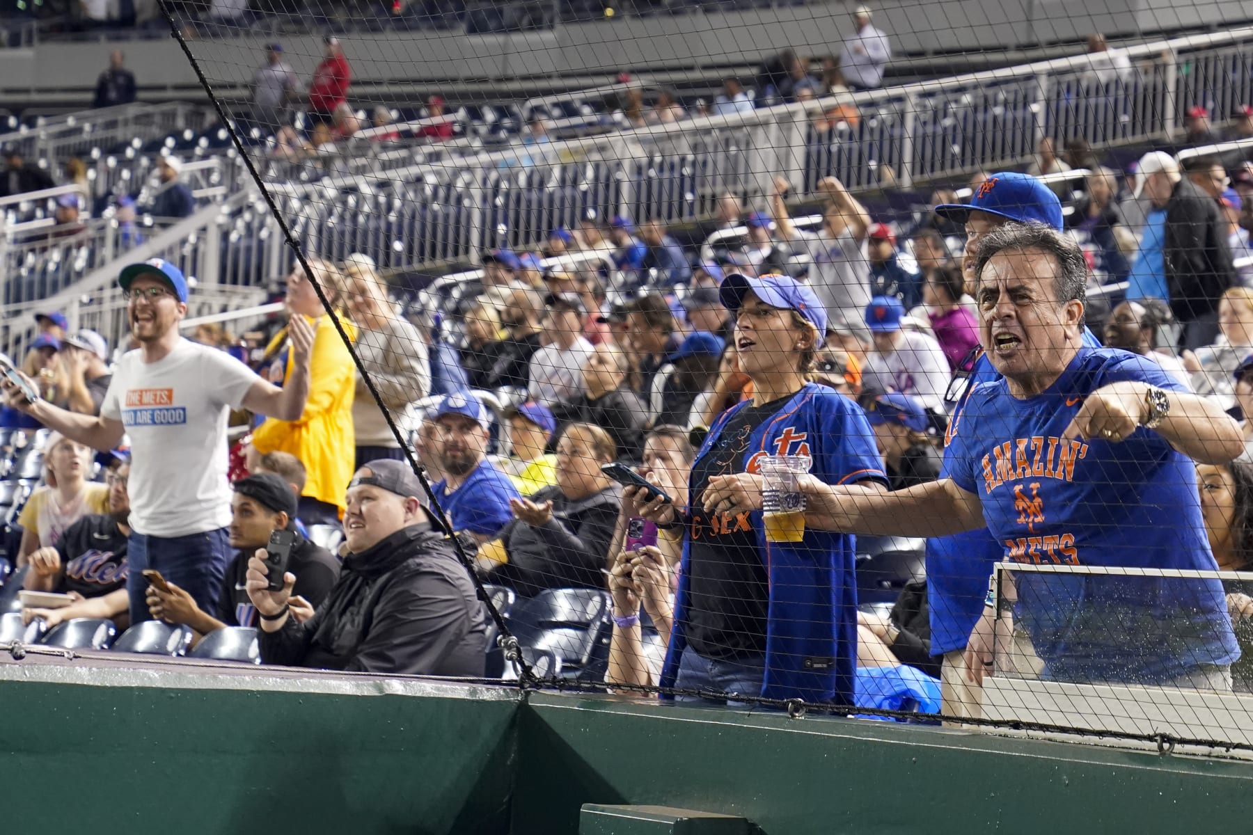 New York Mets fans react after it was announced, after a nearly four-hour weather delay, that the day's baseball game would resume Sunday as part of a doubleheader against the Washington Nationals at Nationals Park, Saturday, May 13, 2023, in Washington. (AP Photo/Alex Brandon) New York Mets fans react after it was announced, after a nearly four-hour weather delay, that the day's baseball game would resume Sunday as part of a doubleheader against the Washington Nationals at Nationals Park, Saturday, May 13, 2023, in Washington. (AP Photo/Alex Brandon)