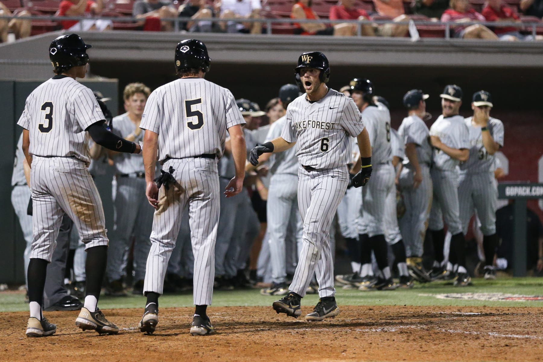 RALEIGH, NC - MAY 19: Wake Forest Demon Deacons infielder Danny Corona (3) and Wake Forest Demon Deacons infielder Pierce Bennett (5) welcome Wake Forest Demon Deacons infielder Michael Turconi (6) to the plate after his three RBI home run during the first game of the series between the Wake Forest Demon Deacons and the North Carolina State Wolfpack on May 19, 2022 on Doak Field At Dail Park. (Photo by Nicholas Faulkner/Icon Sportswire via Getty Images)