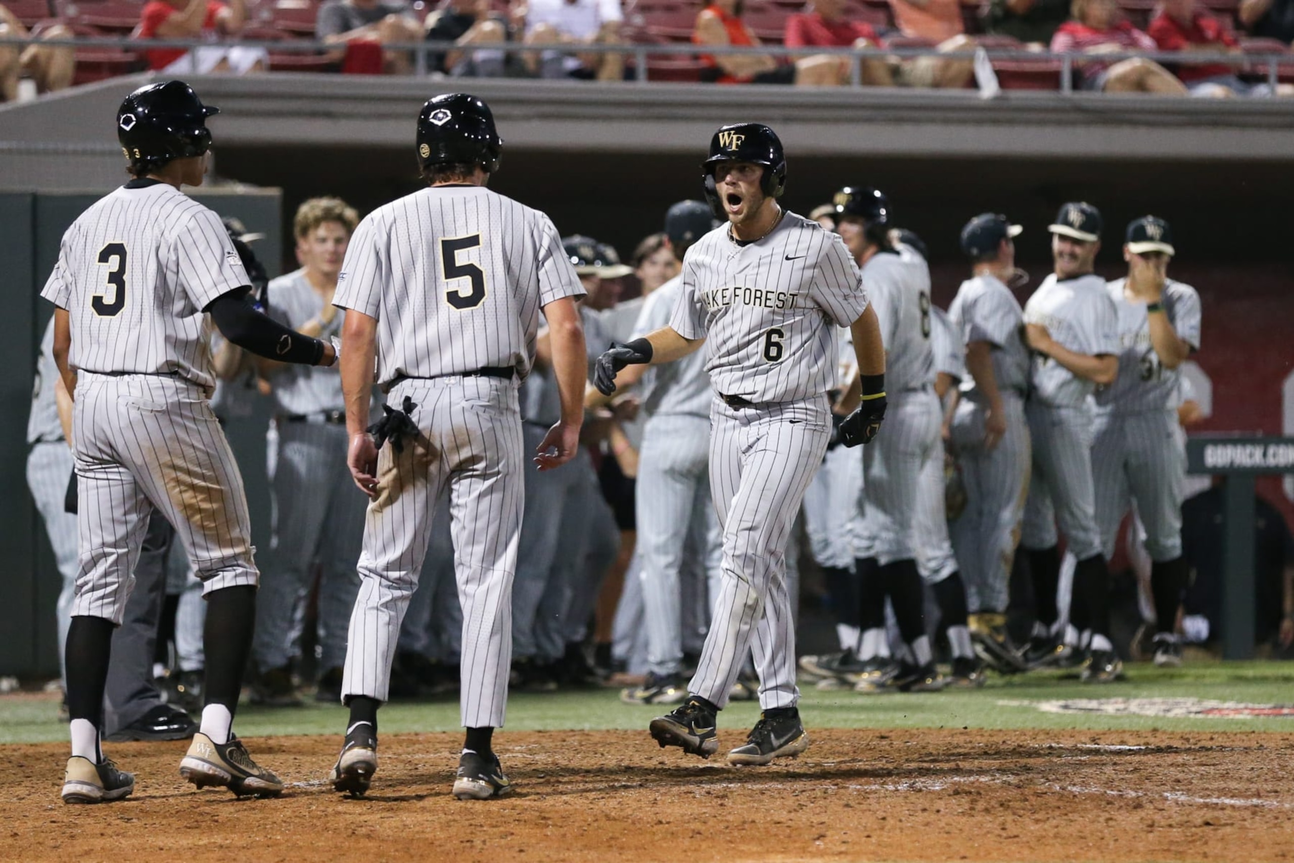 RALEIGH, NC - MAY 19: Wake Forest Demon Deacons infielder Danny Corona (3) and Wake Forest Demon Deacons infielder Pierce Bennett (5) welcome Wake Forest Demon Deacons infielder Michael Turconi (6) to the plate after his three RBI home run during the first game of the series between the Wake Forest Demon Deacons and the North Carolina State Wolfpack on May 19, 2022 on Doak Field At Dail Park. (Photo by Nicholas Faulkner/Icon Sportswire via Getty Images)